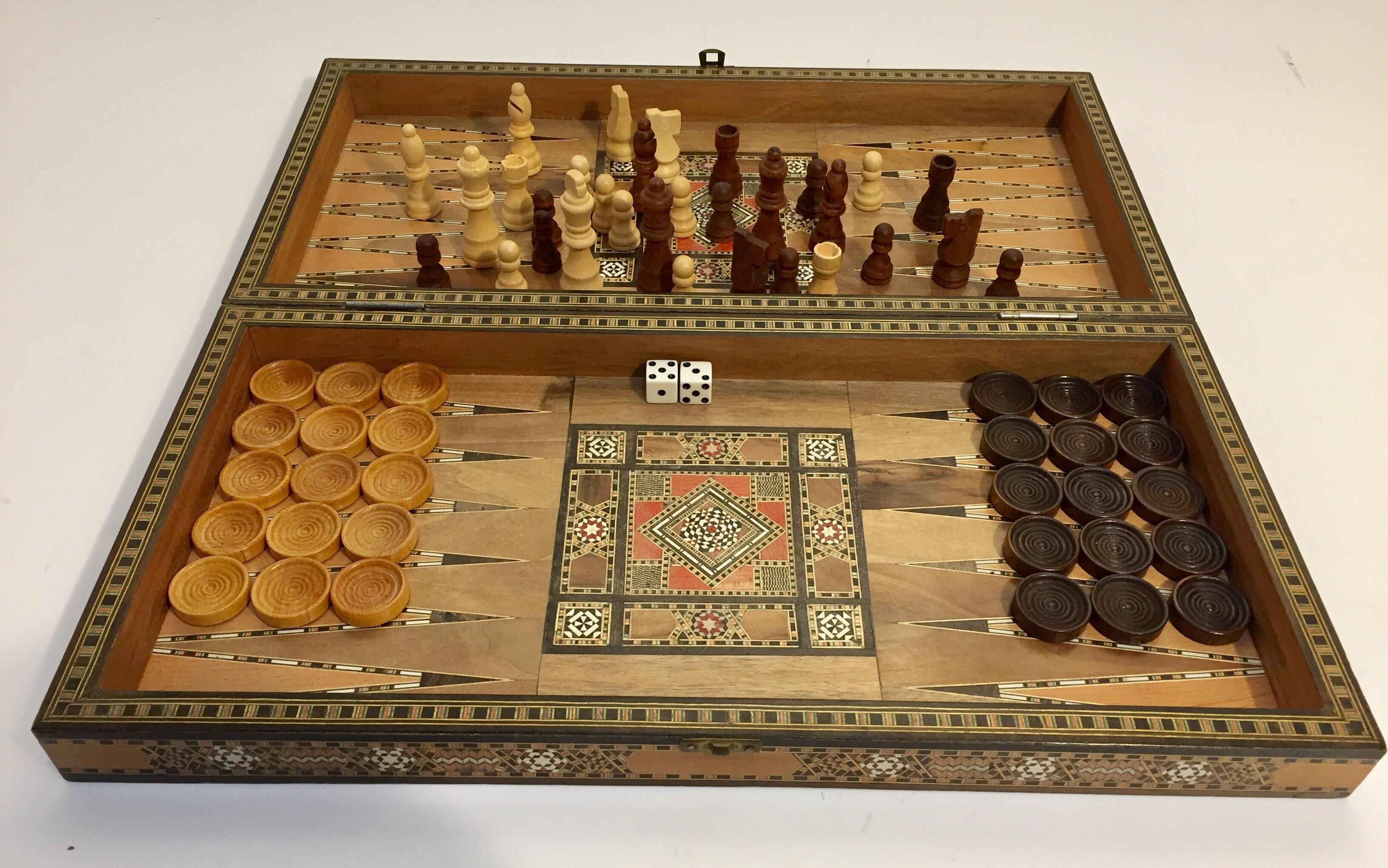 Vintage large Mid Century Syrian inlaid mosaic backgammon and chess game.
Great inlaid micro mosaic hinged marquetry game box features a chess and checker board on the exterior and backgammon board on the interior with all the wooden dice and