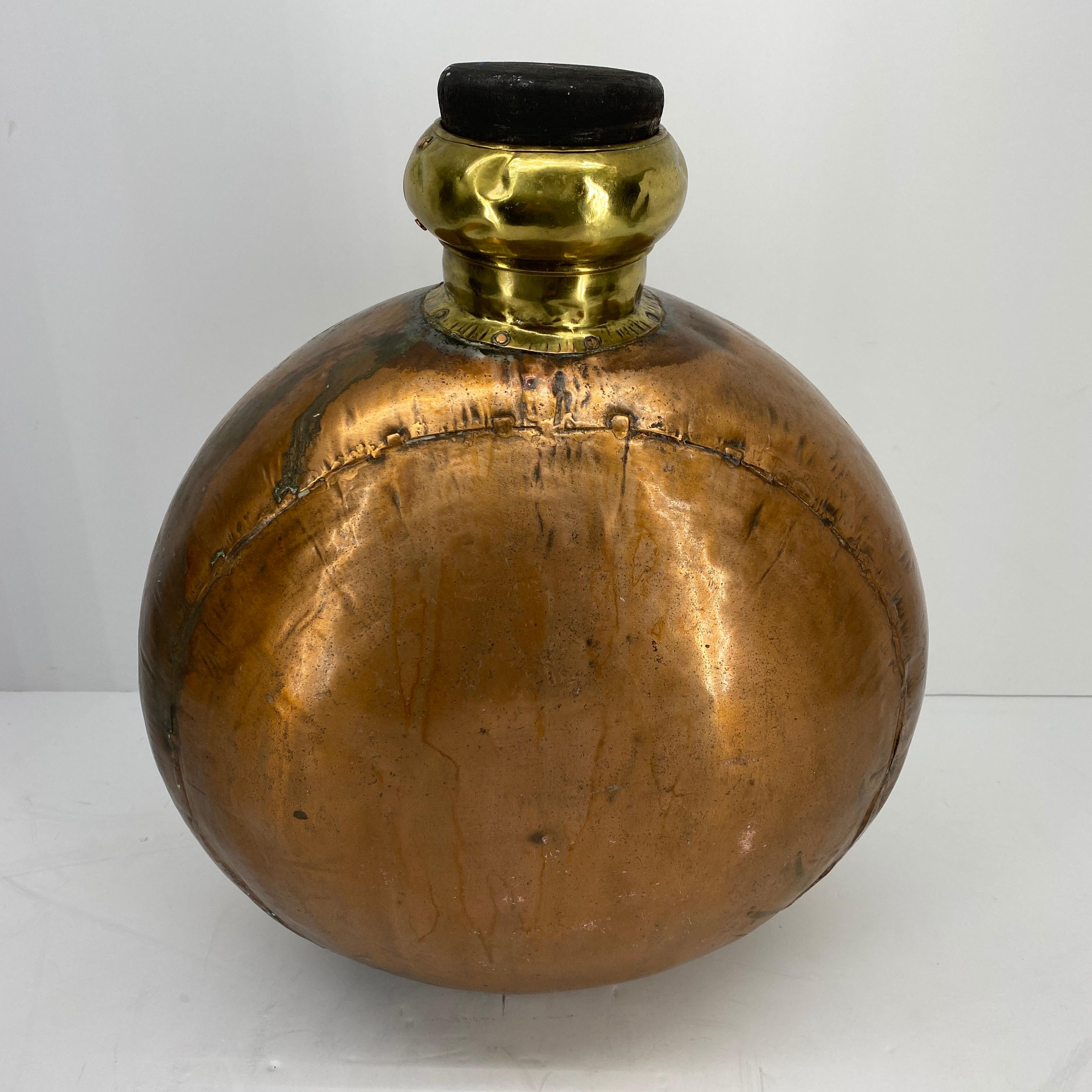 Huge vintage copper and brass decorative bottle with black wooden top.