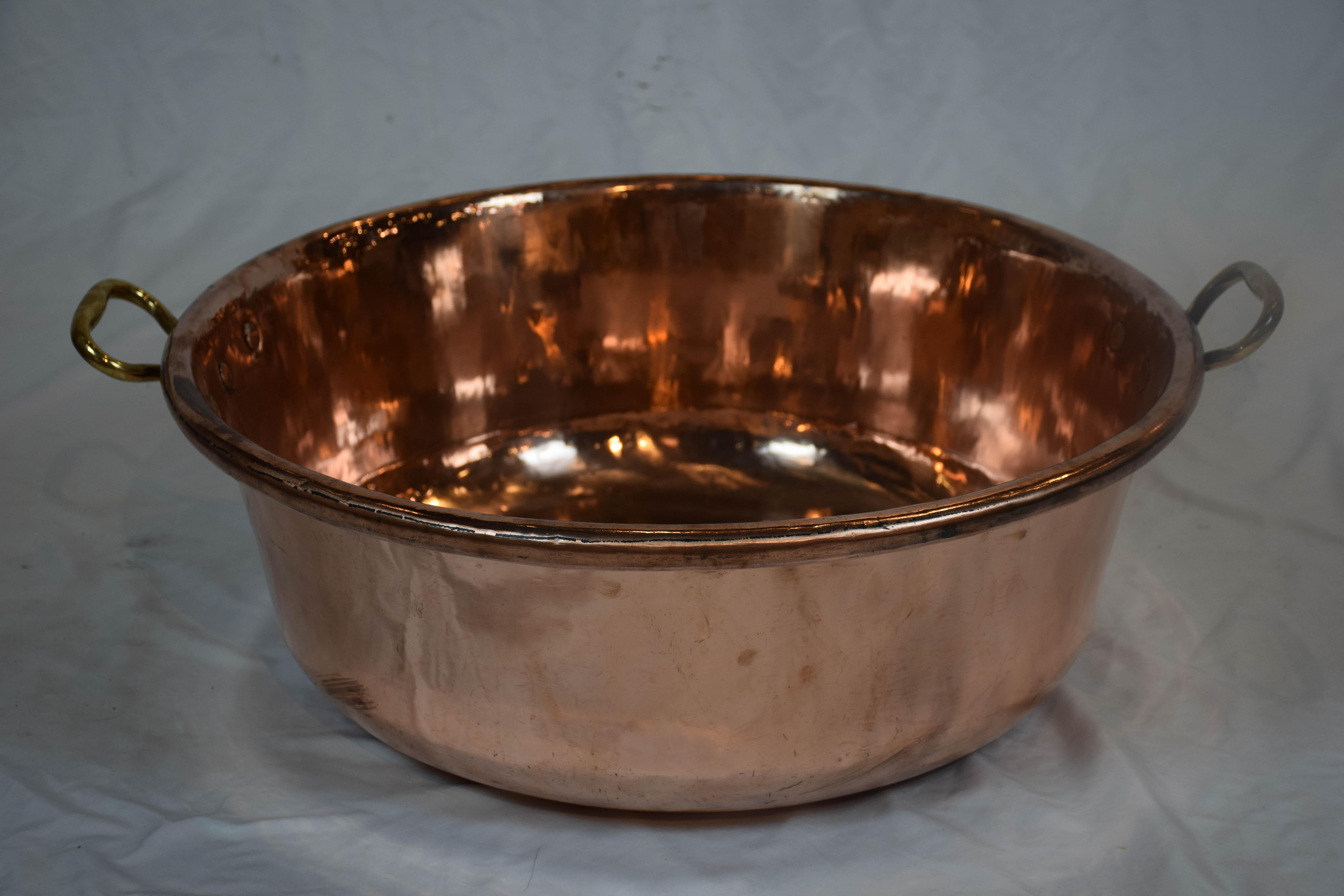 Large copper bowl with brass loop handle. Found in England. This beautiful copper bowl will make a nice addition to any kitchen decor.