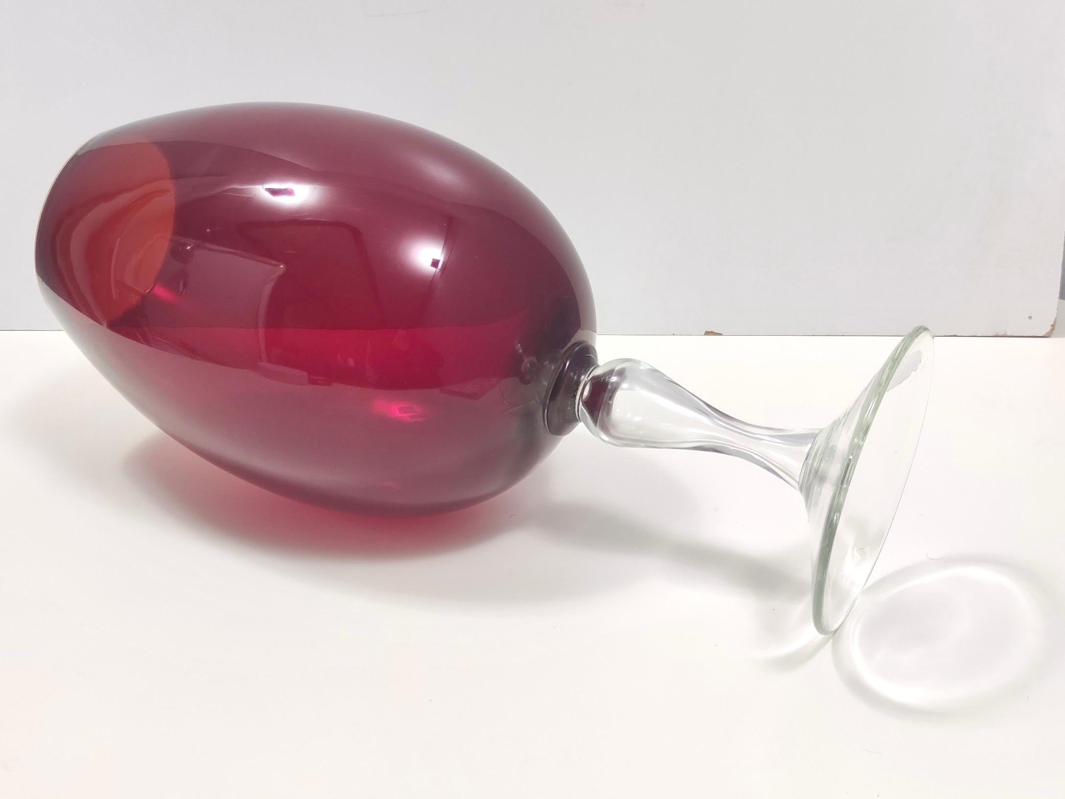Made in Empoli, Italy, 1960s. 
This vase is made in crimson and transparent hand-blown glass and has a drinking glass shape.
It is a vintage item, therefore it might show slight traces of use, but it can be considered as in perfect original