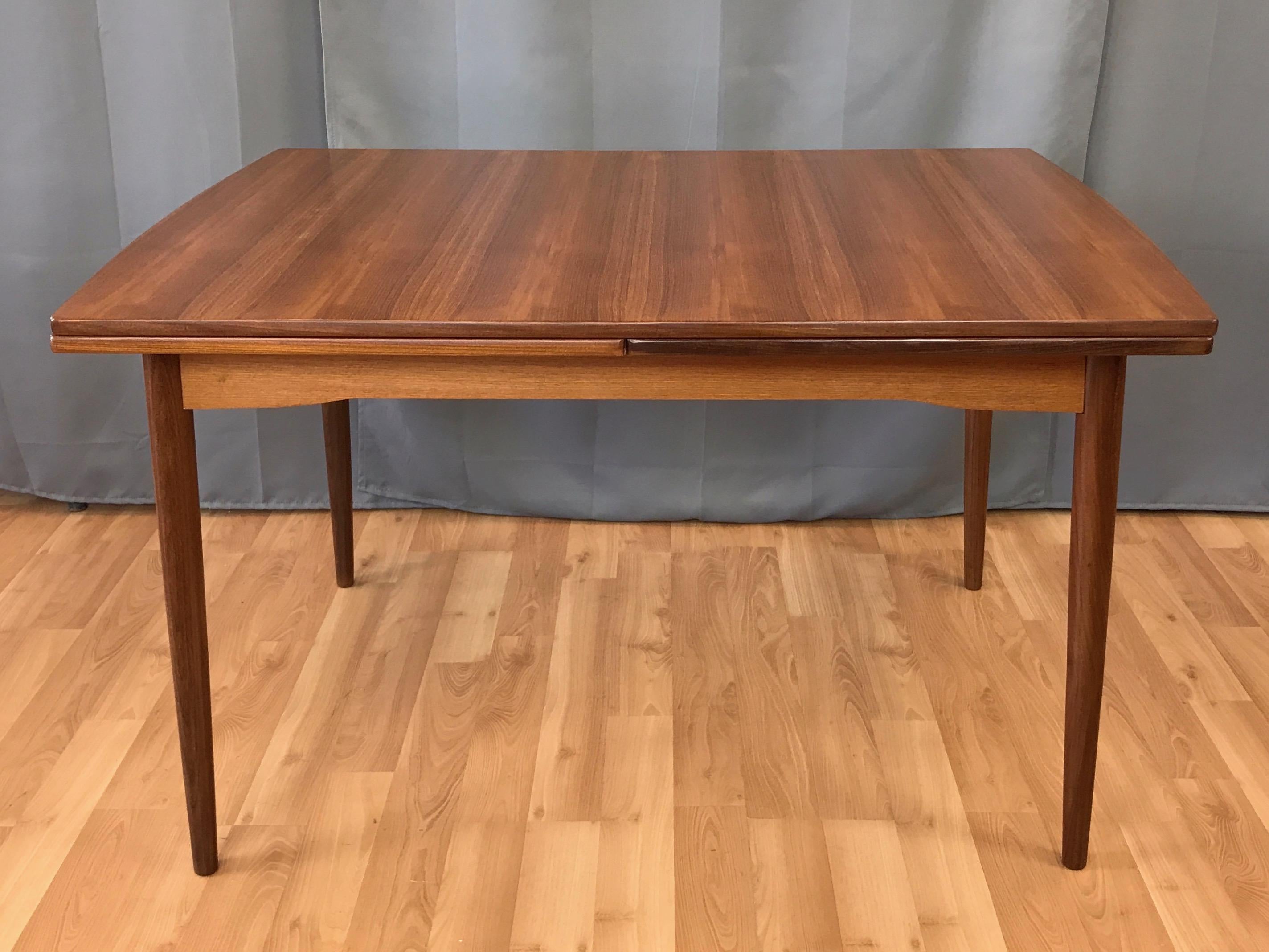 A large 1960s Danish modern draw leaf extendable teak dining table.

Expansive top and leaves have subtly curved ends, and feature vibrantly striped bookmatched teak veneer. On solid teak tapered legs. Length extends from 48 in. to 94 in., seating