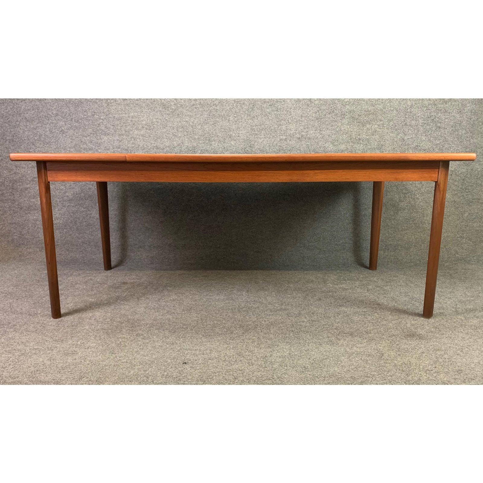 Here is a beautiful and rather large 1960s dining table in teak wood recently imported from Denmark to California before its restoration.
This table features a large top showing vibrant wood grain details supported by a frame mounted on four solid