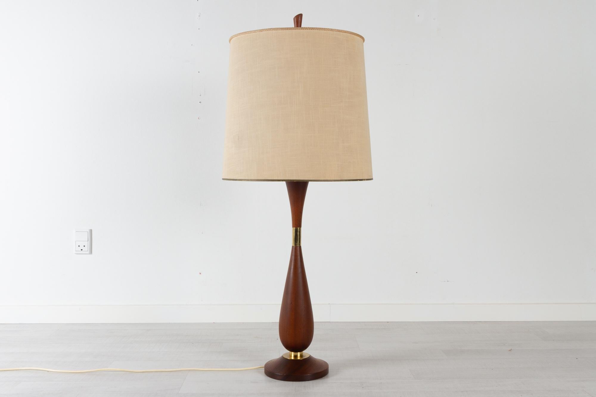 Large Vintage Danish teak table lamp 1950s
Danish mid-century modern organic table lamp in teak and brass with original lamp shade. Socket housing in brass. 
Lamp body and foot in solid teak with natural patina.
Also usable as a floor lamp with a