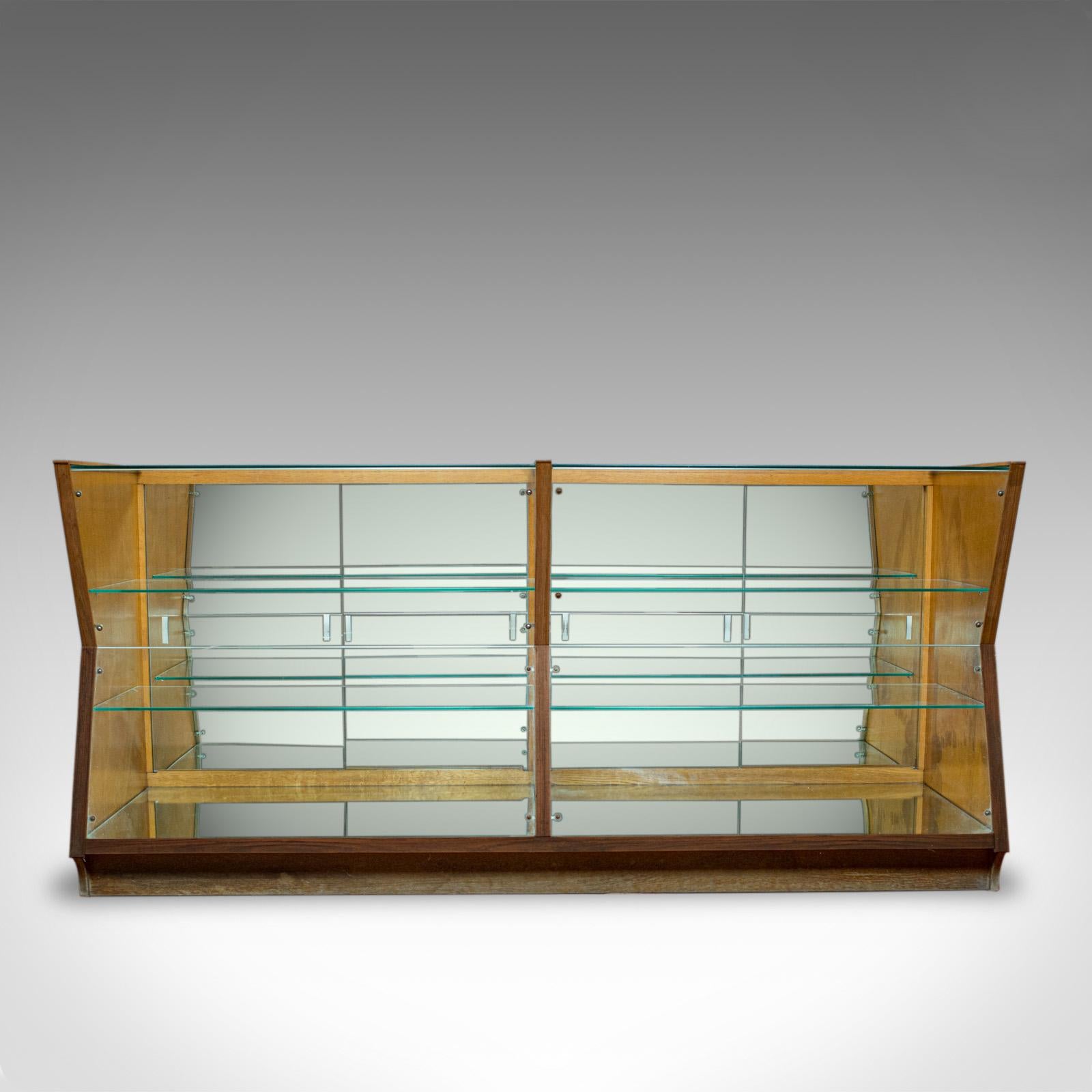 This is a large vintage display cabinet. An English glass and oak, retail shop-fitting showcase in the Art Deco taste, dating to the early 1900s, circa 1930.

Select cuts of oak with fine grain interest and a desirable aged patina
Original glass