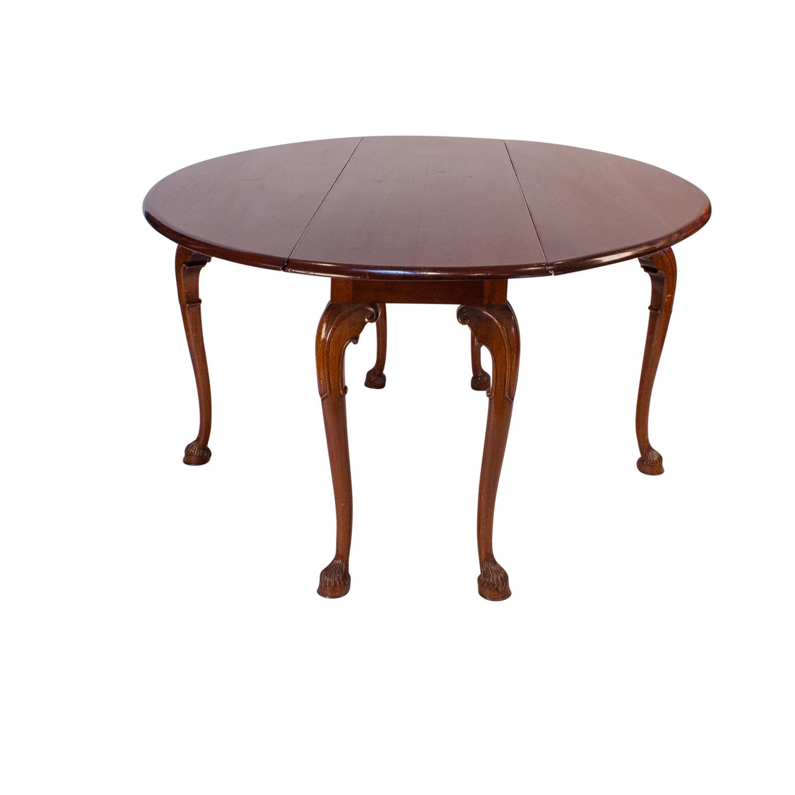 A large vintage English mahogany drop leaf table with hairy paw feet, circa 1960. When opened the table measures 52.5