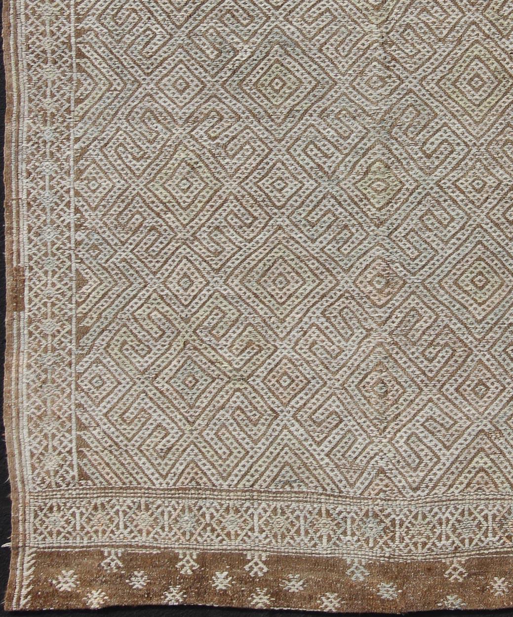 Geometric design vintage Kilim rug from Turkey in natural tones, rug en-165322, country of origin / type: Turkey / Kilim, circa 1950

Featuring a beautiful geometric design rendered in various color tones, and framed at the top and bottom of the