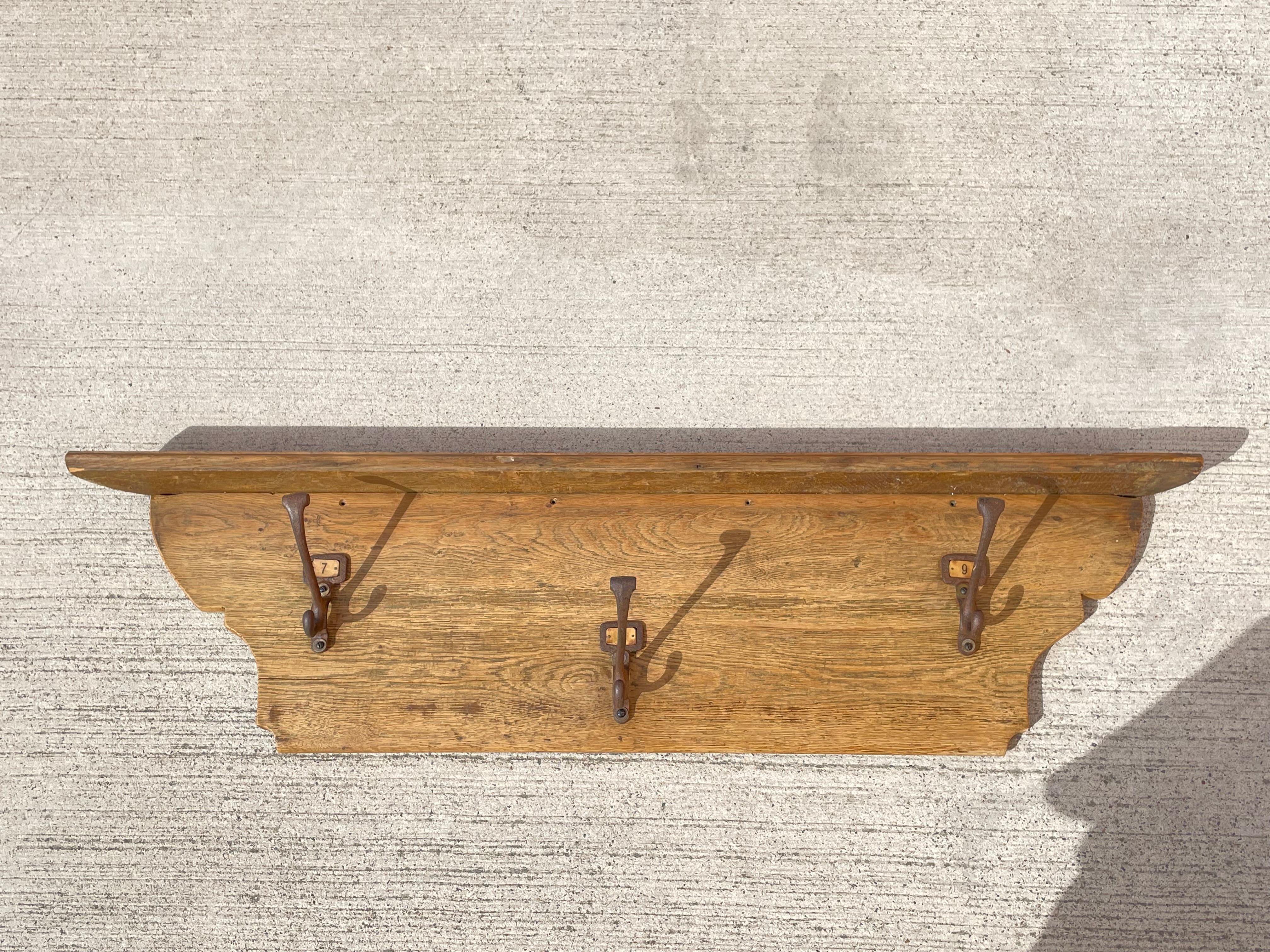 A beautiful old English industrial coat hook. This large coat rack is made in solid oak with three large sized double hooks which are made in iron. Each hook has the original paper number about d the hook. This piece is full of character and patina.