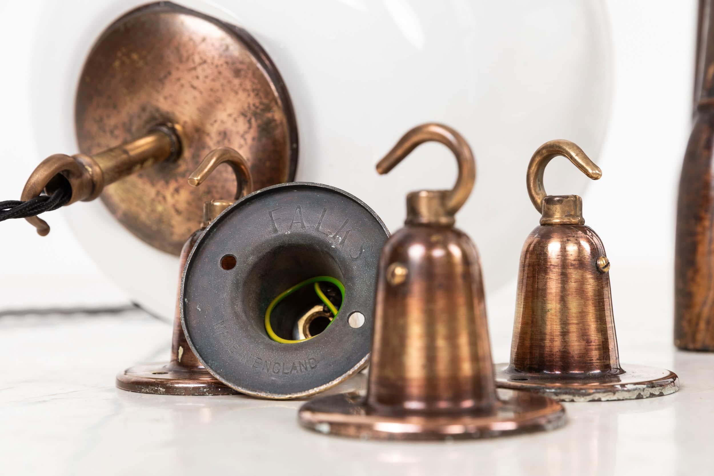 

A beautiful tulip shaped opaline glass pendant light made by Falks. c.1930

Thought to have to been salvaged from a former RAF base. Hand blown and rolled opaque opened bottom glass shade with original copper plated brass monks cap gallery and