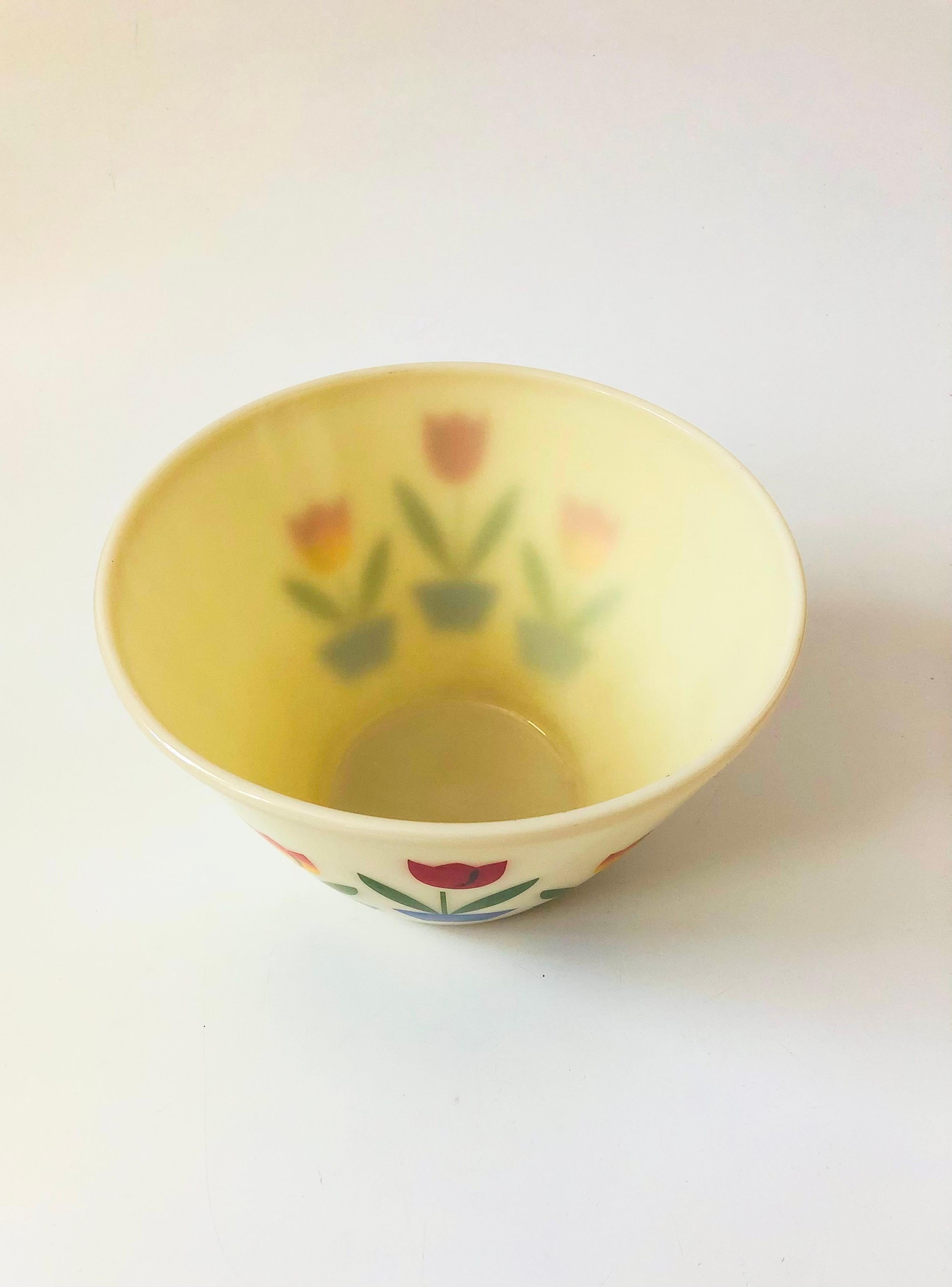 A large vintage mixing bowl made by Fire King. Made out of thick milk glass with a lovely tulip pattern on two sides.