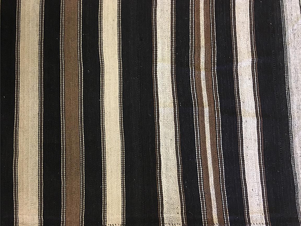 Il tappeto kilim turco vintage risale agli anni '50 circa. È stato tessuto a mano utilizzando un misto lana della migliore qualità, che ne ha garantito la morbidezza e la durata. Il suo motivo è caratterizzato da strisce ripetute allover di