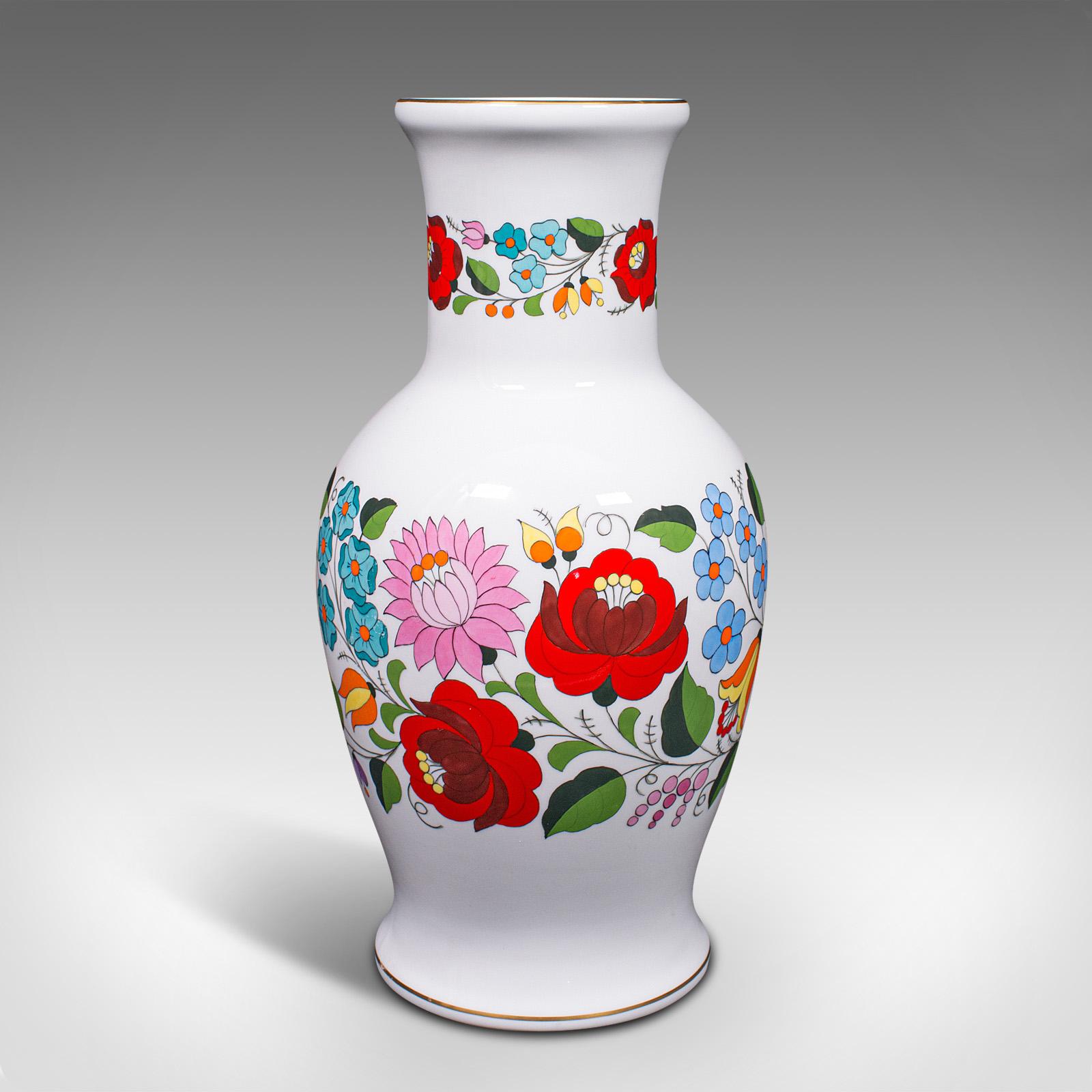 This is a large vintage flower vase. An Hungarian, ceramic baluster vase with colourful decoration, dating to the late 20th century, circa 1980.

Excellent colour accentuates the crisp white ground
Displays a desirable aged patina and in good