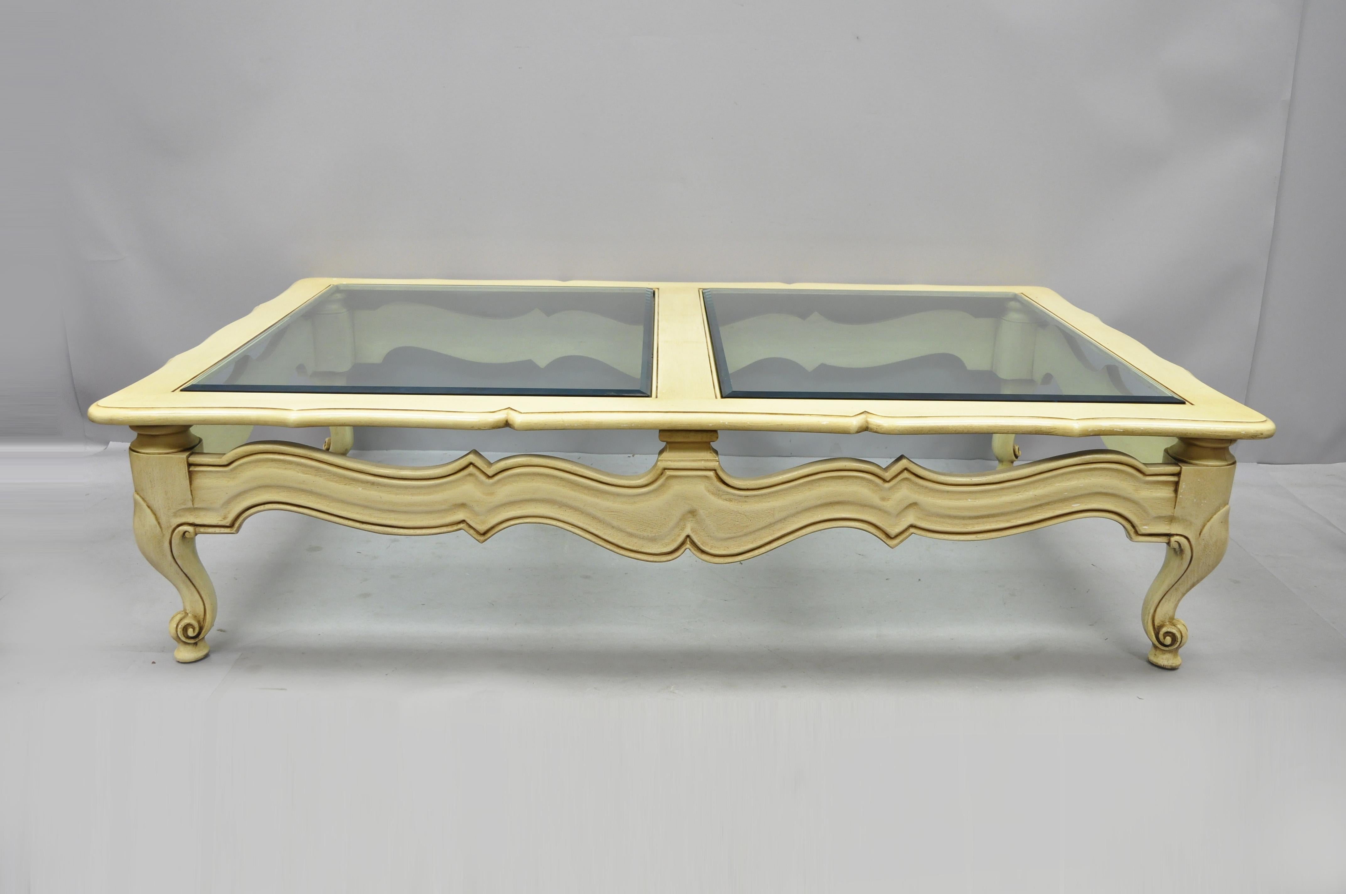 Large vintage French Hollywood Regency style beveled glass cream coffee table. Item features very large impressive size. (2) thick beveled glass tops, pierce carved base, solid wood construction, cabriole legs, great style and form, circa mid-20th