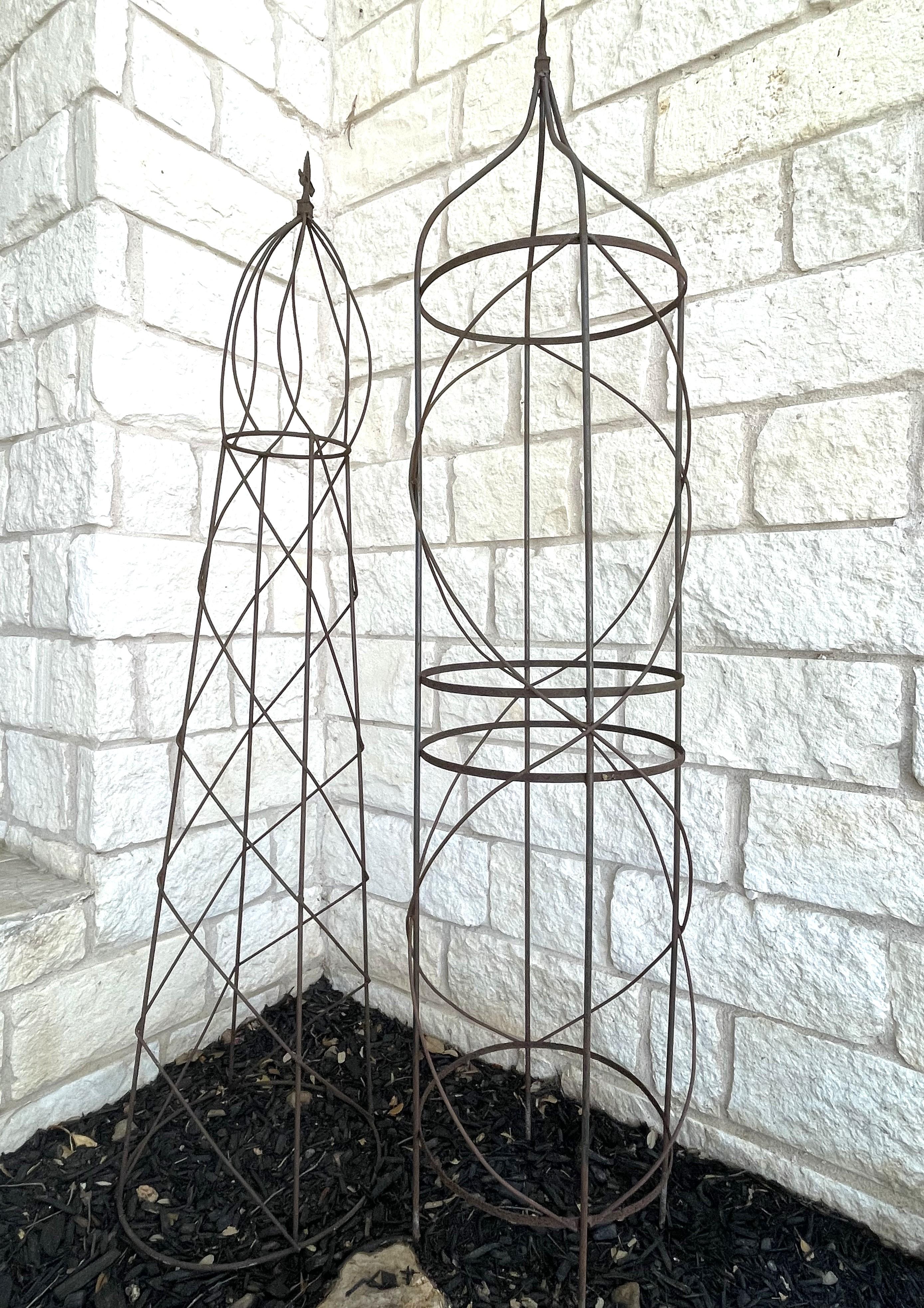 A lovely garden folly! A great vintage find. Made of iron, this pair of vintage French garden trellises or topiaries dates to the late 19th or early 20th century and has patinaed very nicely. Each trellis is solid and sturdy. They are ready to serve