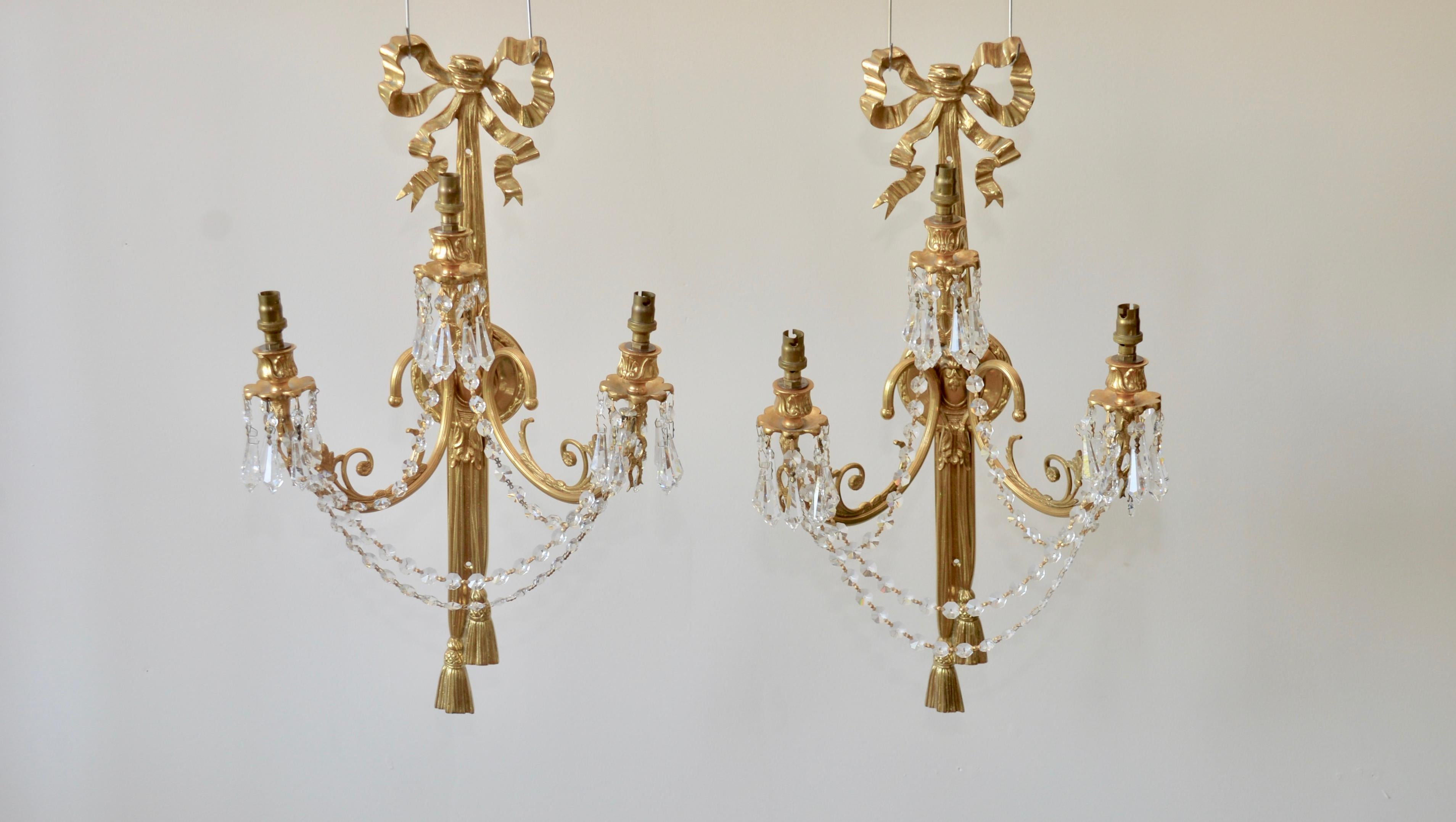 A highly decorative and impressive pair of wall lights, superb quality gold gilded brass with cut glass droplets. Three curved branches with lovely detail two opposing and one central branch set on a highly decorative large ribbon mount trailing