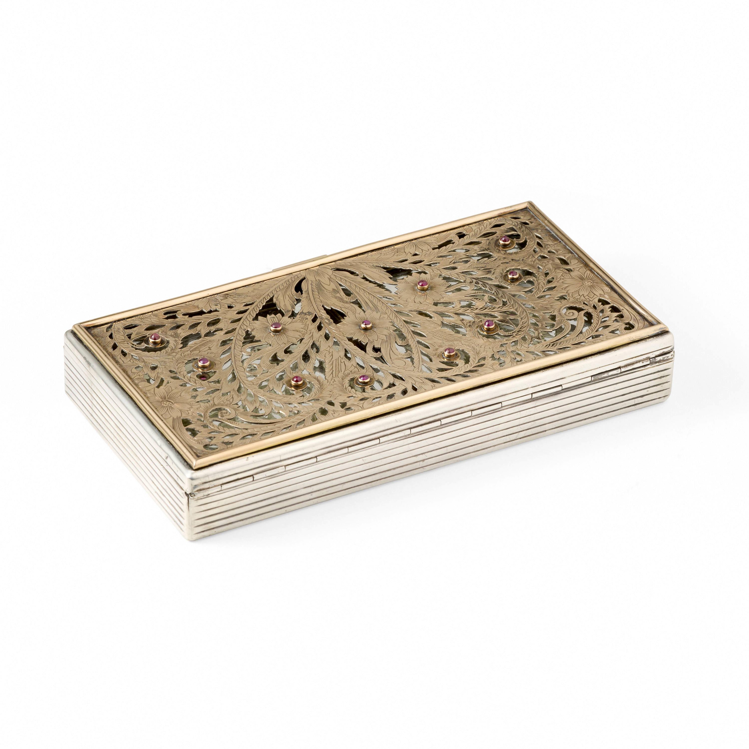 A large silver compact case with gilt surface and inset rubies by Boucheron Paris circa 1930s-1940s, of Art Deco period and style. The silver case is quote large compared to similar pieces and can almost function like a small purse. It features an