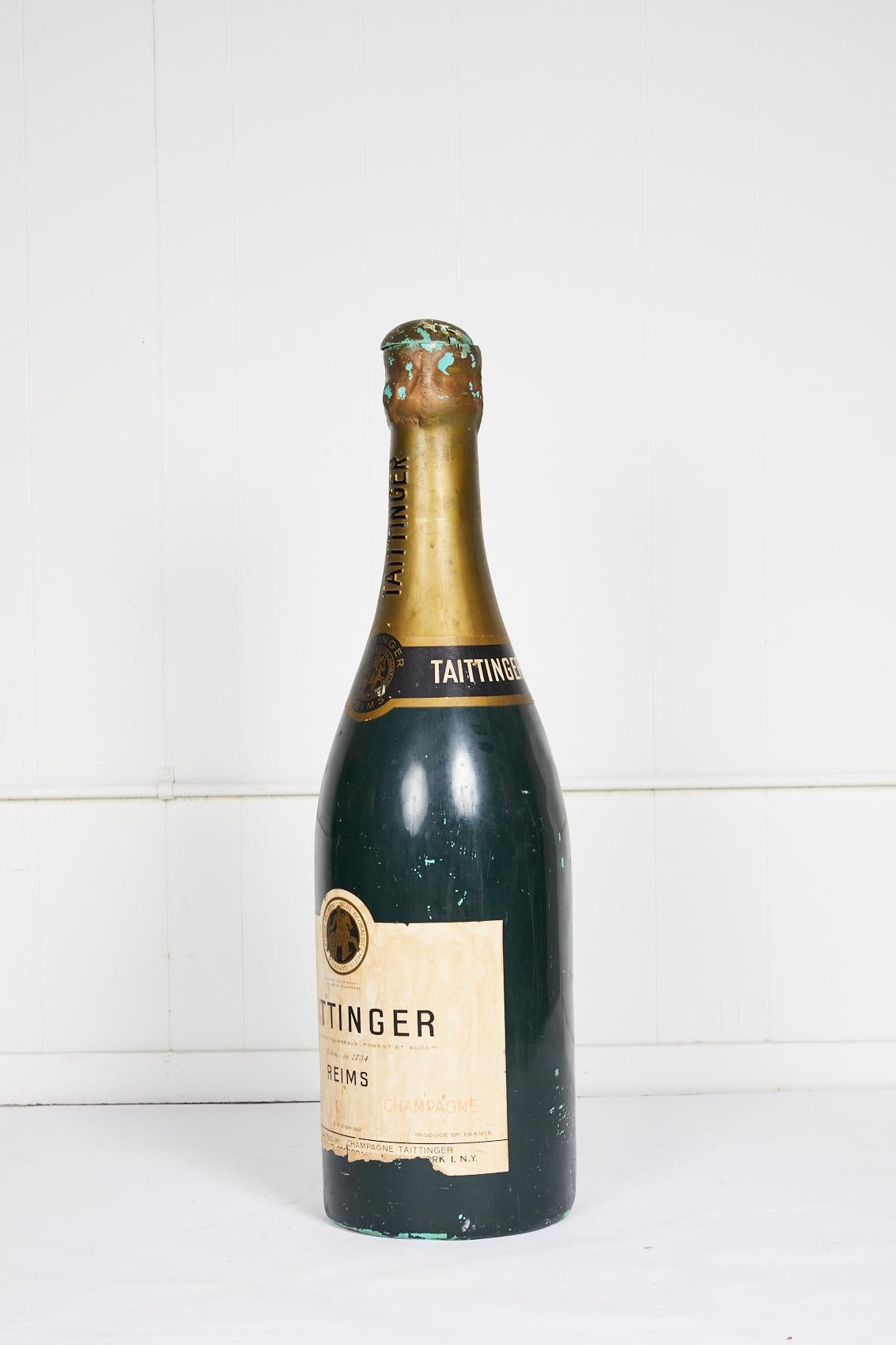 Bouteille de champagne Taittinger française vintage du 20e siècle fabriquée en matériau composite et utilisée comme accessoire publicitaire. Le bouchon de la bouteille a été ouvert.