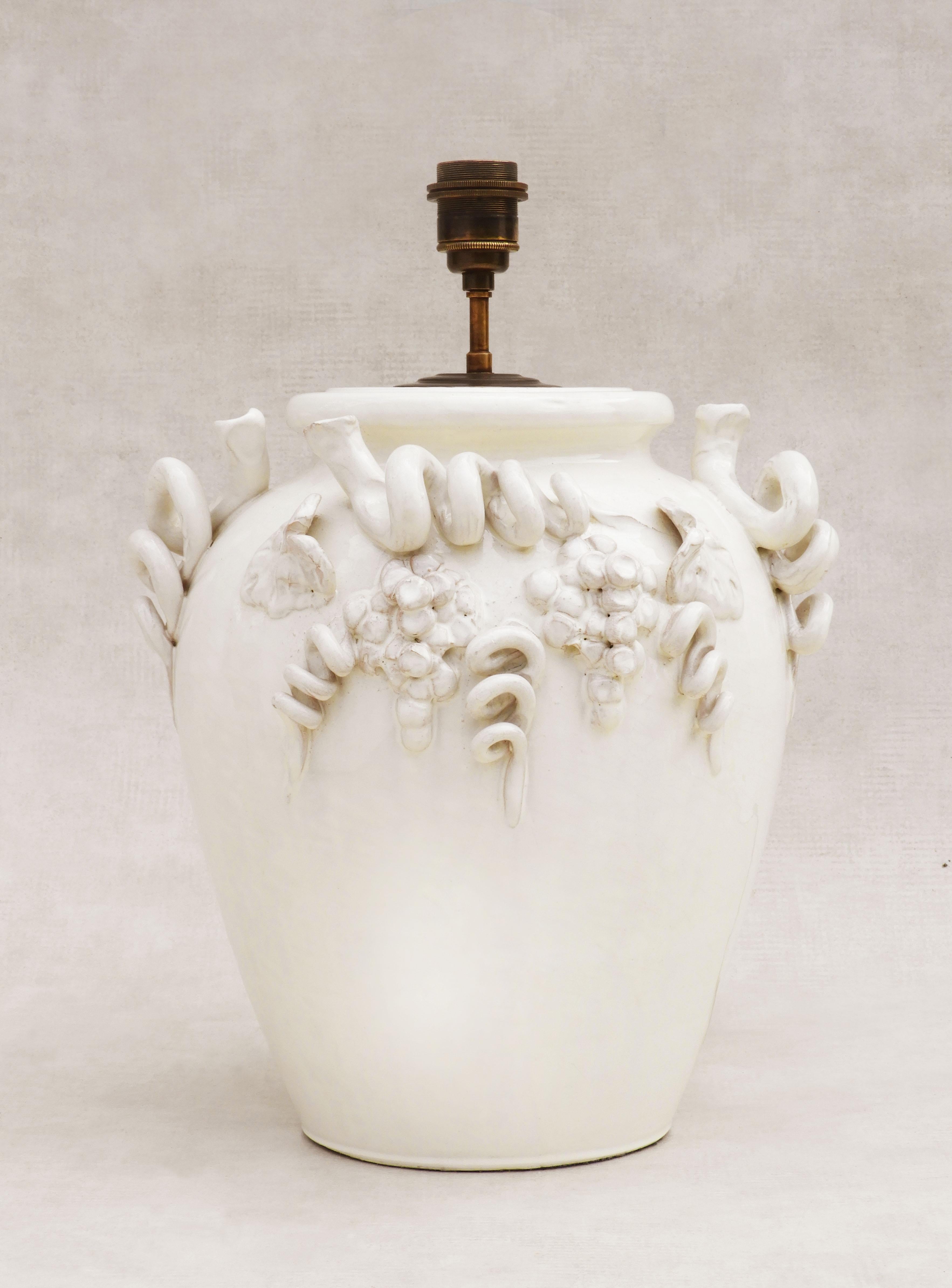 Charming wine-themed, white-glazed, terracotta table lamp C1980s France. Heavy, nicely proportioned, jar-shaped lamp, decorated in relief with grapes, leaves and vine tendrils and finished in a glossy white ceramic glaze. 
In good vintage