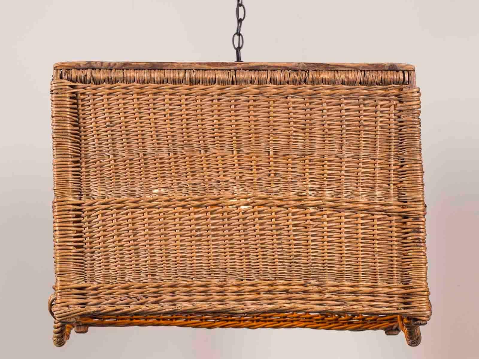 This large vintage French rectangular woven wicker basket from France, circa 1920 has been made into a custom chandelier fixture with the addition of a handmade light source concealed within the interior. Please enlarge the photographs to see the