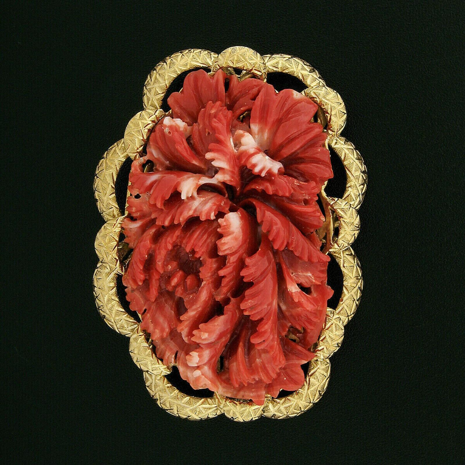 This large, unique, and very well-made vintage brooch was crafted from solid 18k yellow gold. It features a GIA certified natural coral set into a beautiful hand-engraved and textured frame. The coral is a rich orange-red color and is masterfully