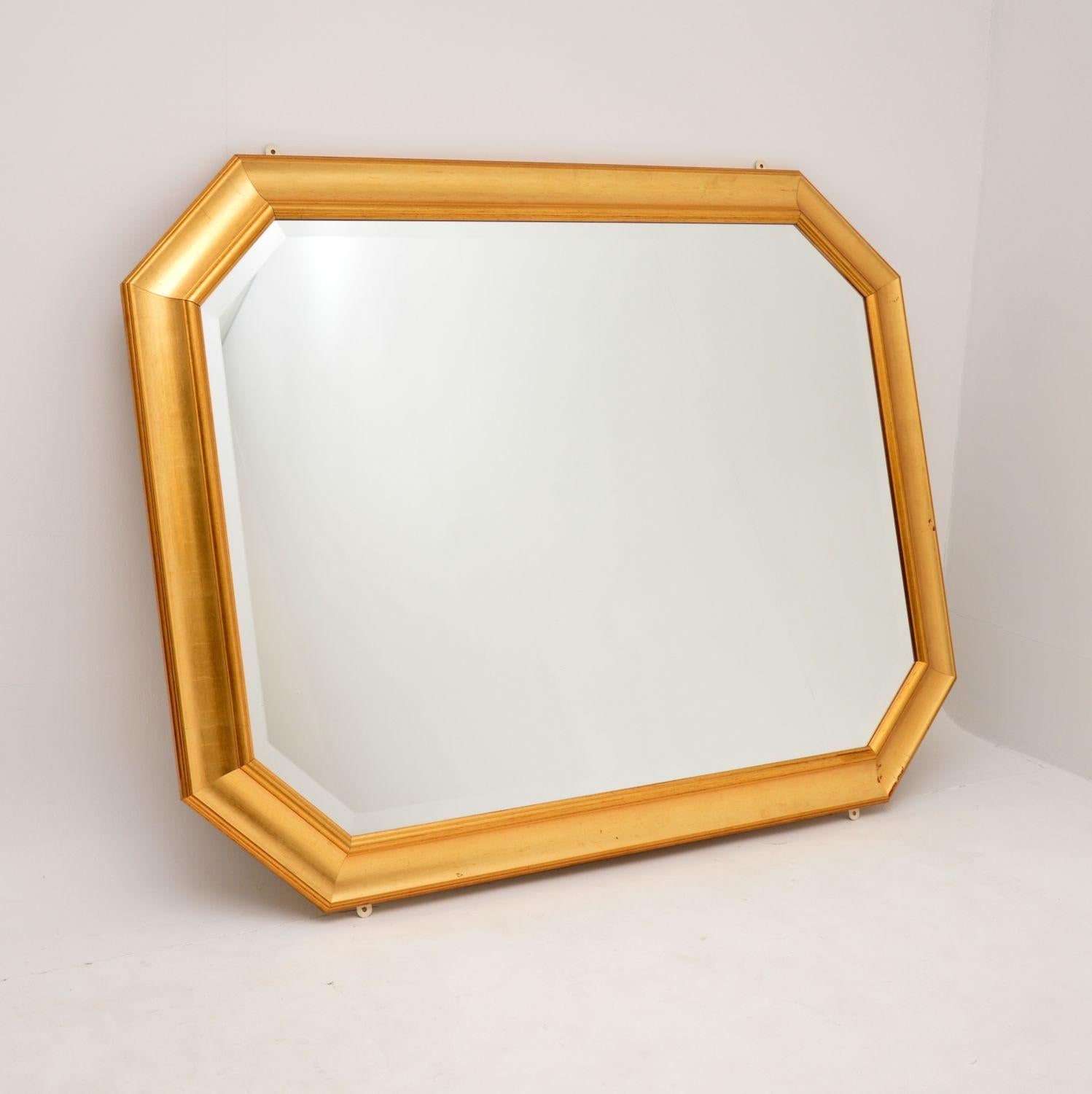A fine quality and very large vintage gilt wood mirror. This was made in England, it dates from around the 1970-80’s.

This is beautifully made and is very impressive. It has bevelled glass which is in great condition. The gilt wood frame is