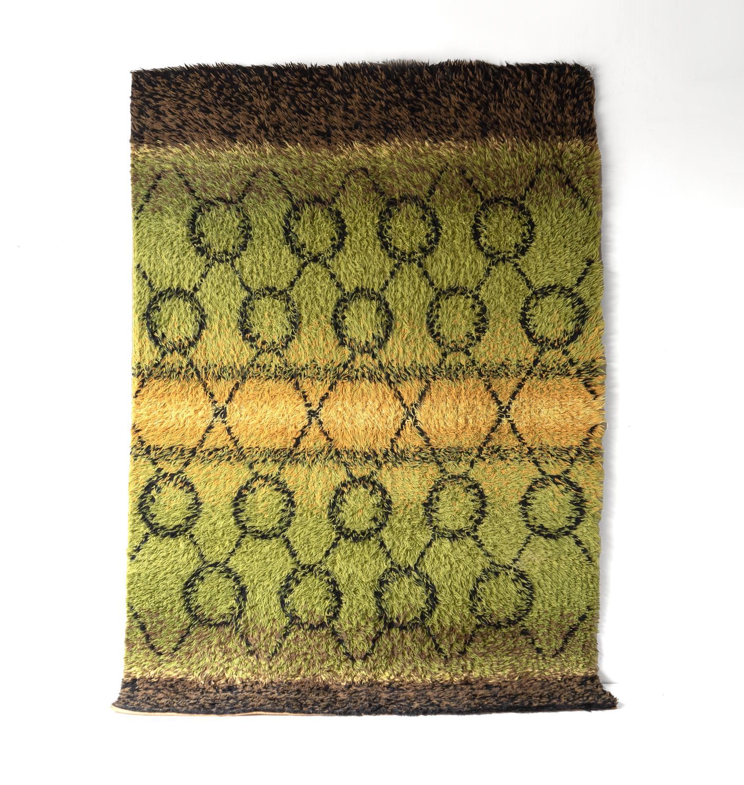 LARGE VINTAGE GREEN WOOL SHAG RUG , MID CENTURY RYA CARPET 1960S

A woven rug with a deep shag pile of mainly green ground with bands of yellow and brown flecked with black. With a linear black and rep4taed circle design.

Dating from the