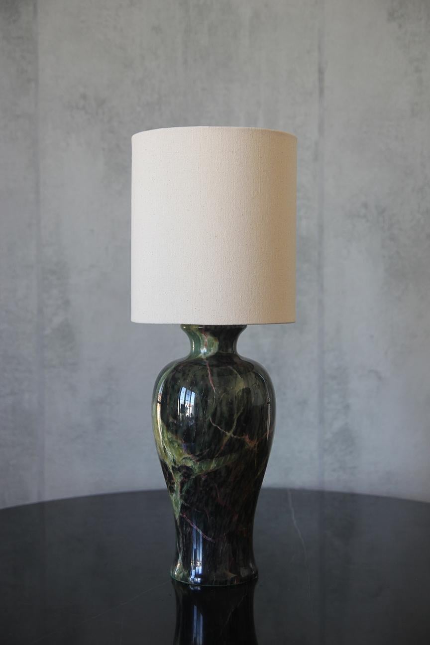 This stunning vintage Mid-Century Modern table lamp is crafted from exquisite jade marble with a glossy glazed finish. Its elegant design showcases a rich palette of green shades, artistically accented with subtle hints of yellow, black, and red,