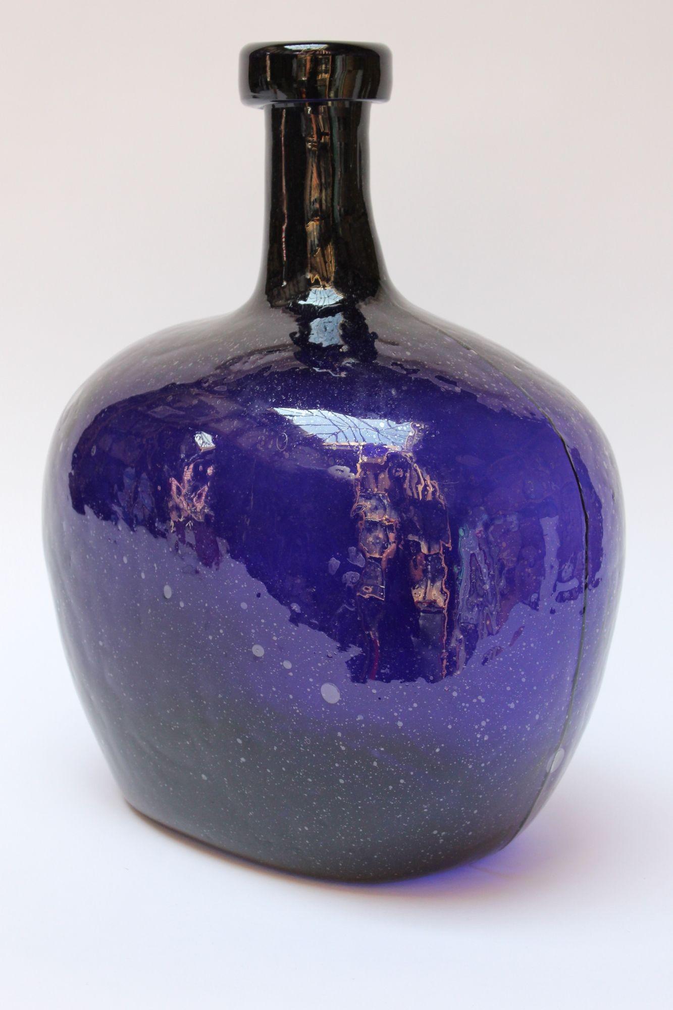 Demijohn / Carboy originally used for transporting wine (ca. Mid-20th century, USA). Composed of 'blown-to-mold' glass (a method accepted as 'hand-blowing') exhibiting trapped air bubbles within the glass itself with a thick lip. Striking indigo