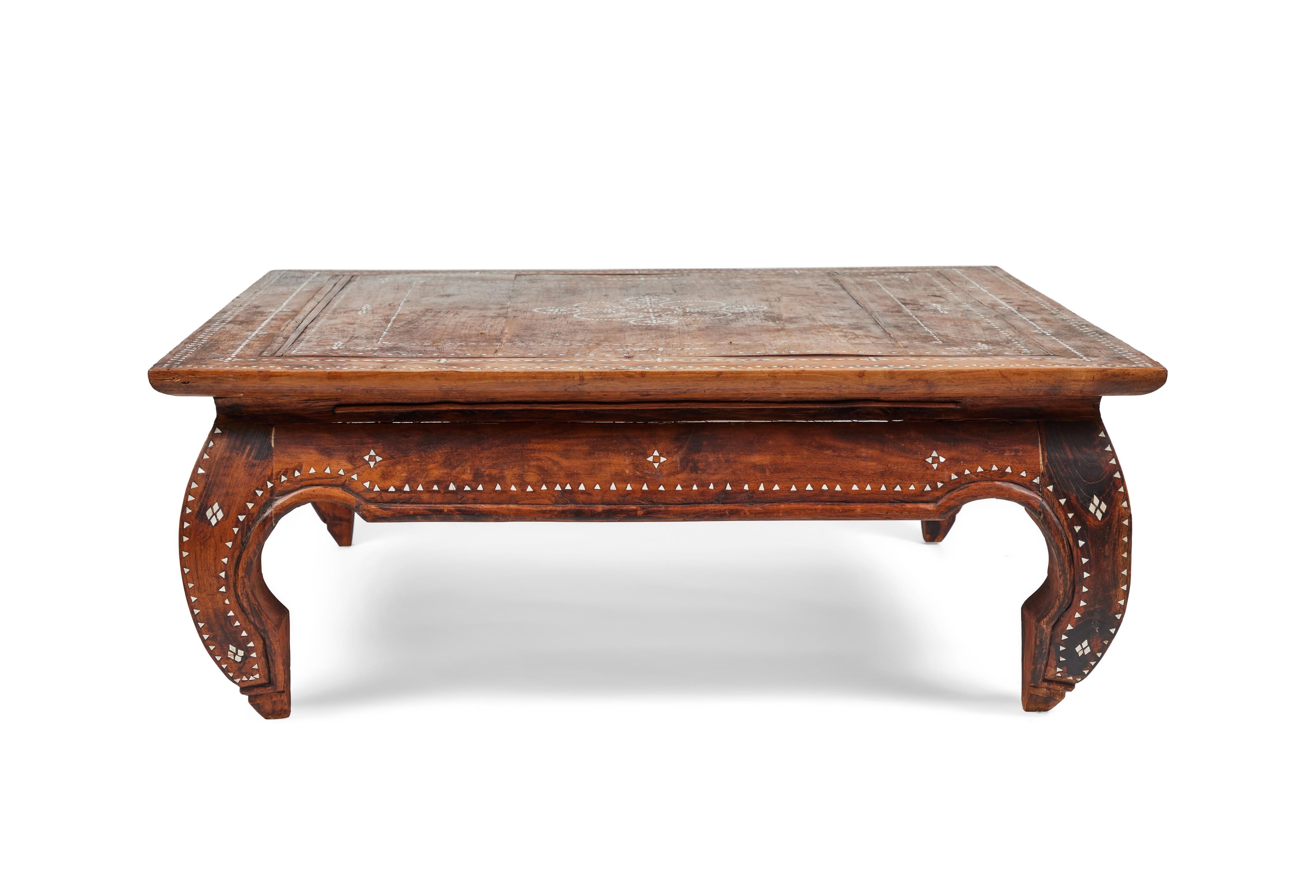 Striking large vintage hand-carved square wood coffee table is from India. It has a beautiful decorative inlaid mother of pearl design on the top, sides and down the unique inward turned legs.

