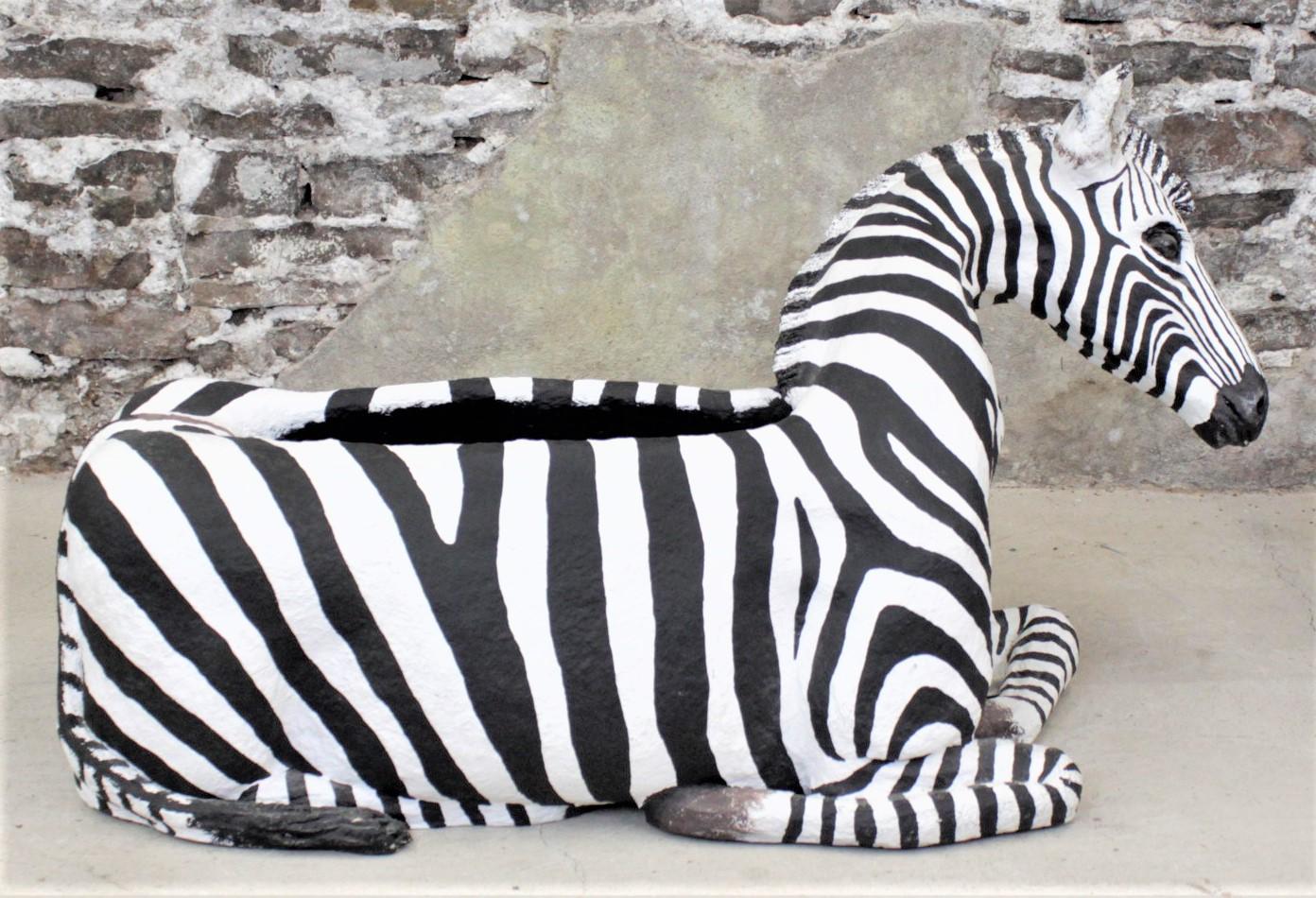 This large and substantial zebra sculpture or planter box was made by Monica Oliver, and unknown artist, in 1990 in a modern realistic style. The sculpture appears to be composed of various materials such as paper mache, fiberglass and resin and