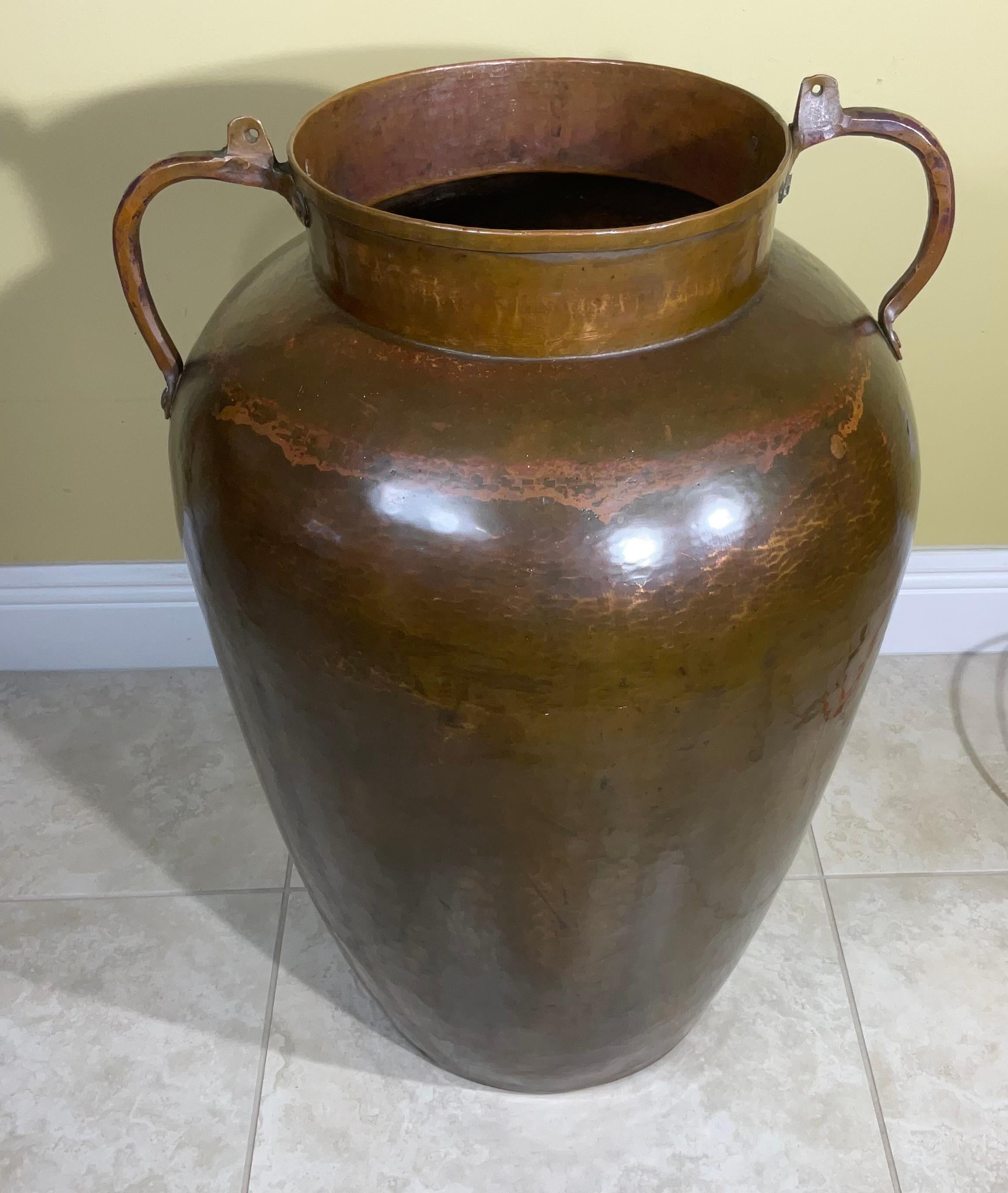 Exceptional Hand crafted hammered copper vessel, probably made for American moonshine era Producer. The large copper vessels were used for storage. However this artisan vase has two decorative handles and is functional and could be use even as