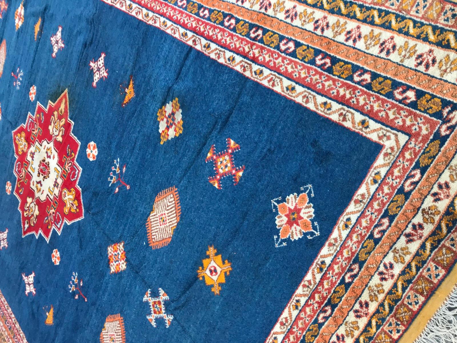 Nice large midcentury Berbere Moroccan rug, with beautiful tribal design with a central medallion and beautiful colors with blue field and red, green and orange, entirely hand knotted with wool velvet on wool foundation.