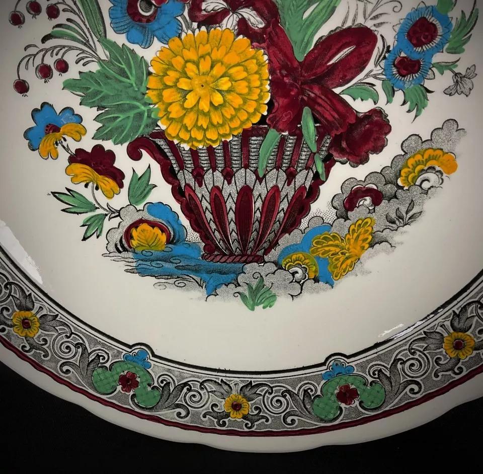 This exquisite large faience plate by Boch Holland for Royal Sphinx showcases a beautifully detailed hand-painted floral design. Crafted with expert skill, the plate embodies traditional Dutch artistry and makes an eye-catching decorative piece for