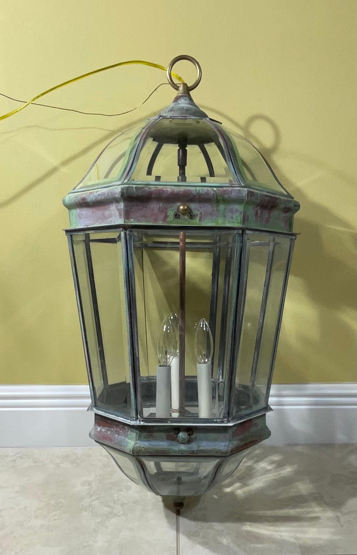Exceptional large hanging lantern made of solid brass, quality workmanship, electrified with three 60/watt light , beautiful beveled glass. Great light exposure.
Suitable for wet location.  Two glass compartment restored to flat glass , the front