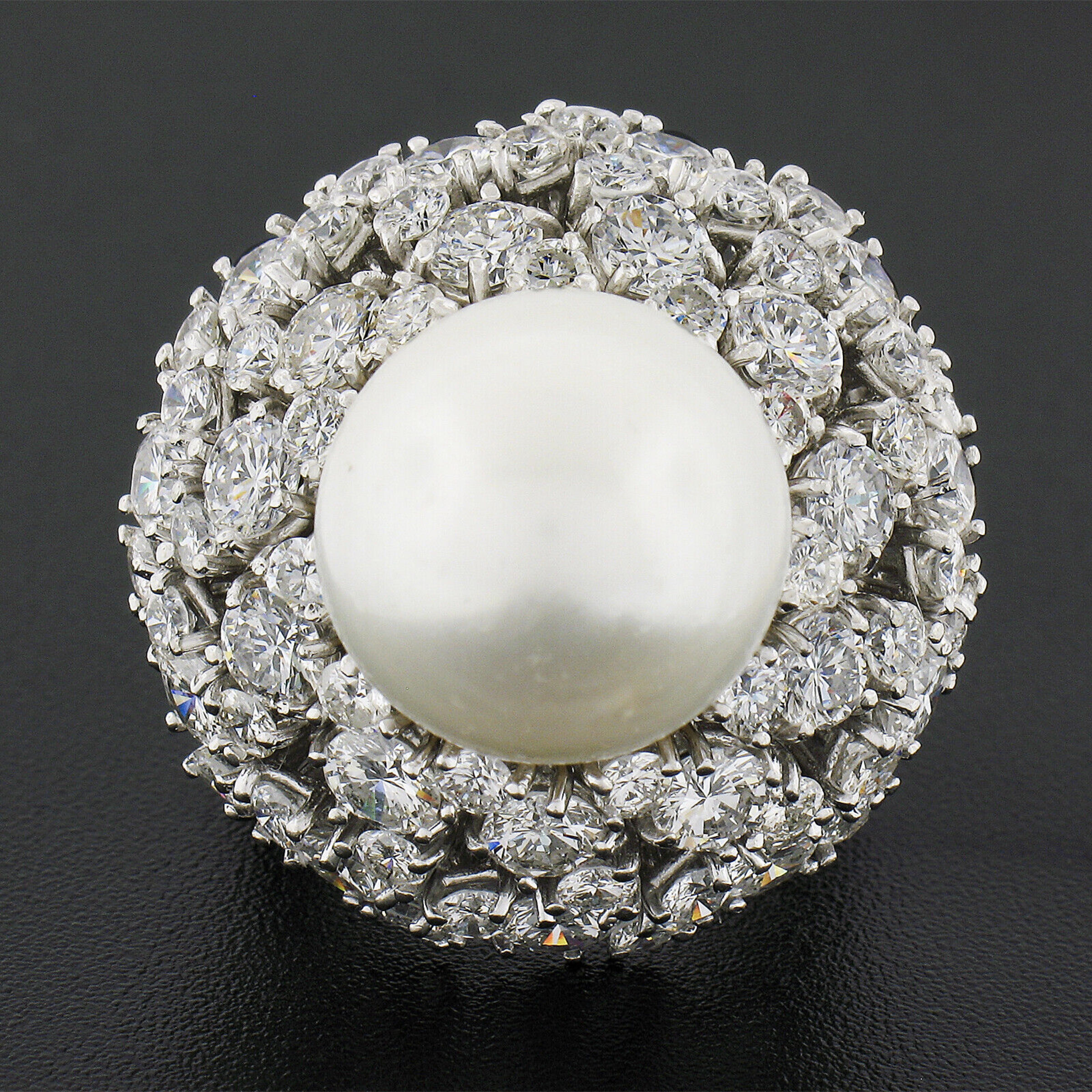 This absolutely magnificent and very well made midcentury cocktail ring was hand crafted from solid platinum and features an amazing, large, cultured pearl that is set above a sea of super fiery round brilliant cut diamonds. The incredible 14mm