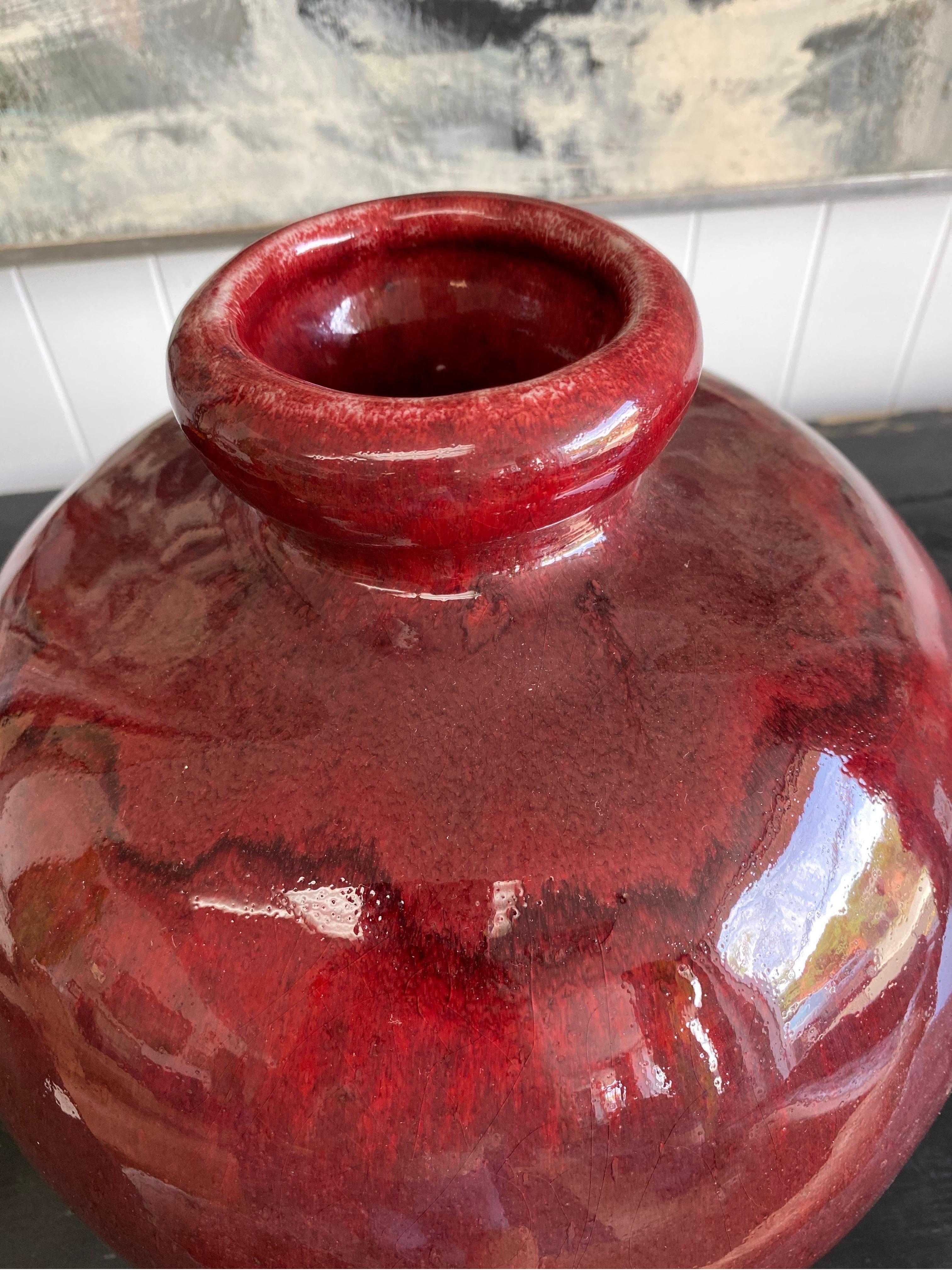 Large vintage ceramic vase by Texas ceramist Harding Black, signed and dated 1985. Self taught Harding Black was known for his extensive glaze research and techniques. This pottery piece is a deep red and shows drip glaze towards the bottom of the