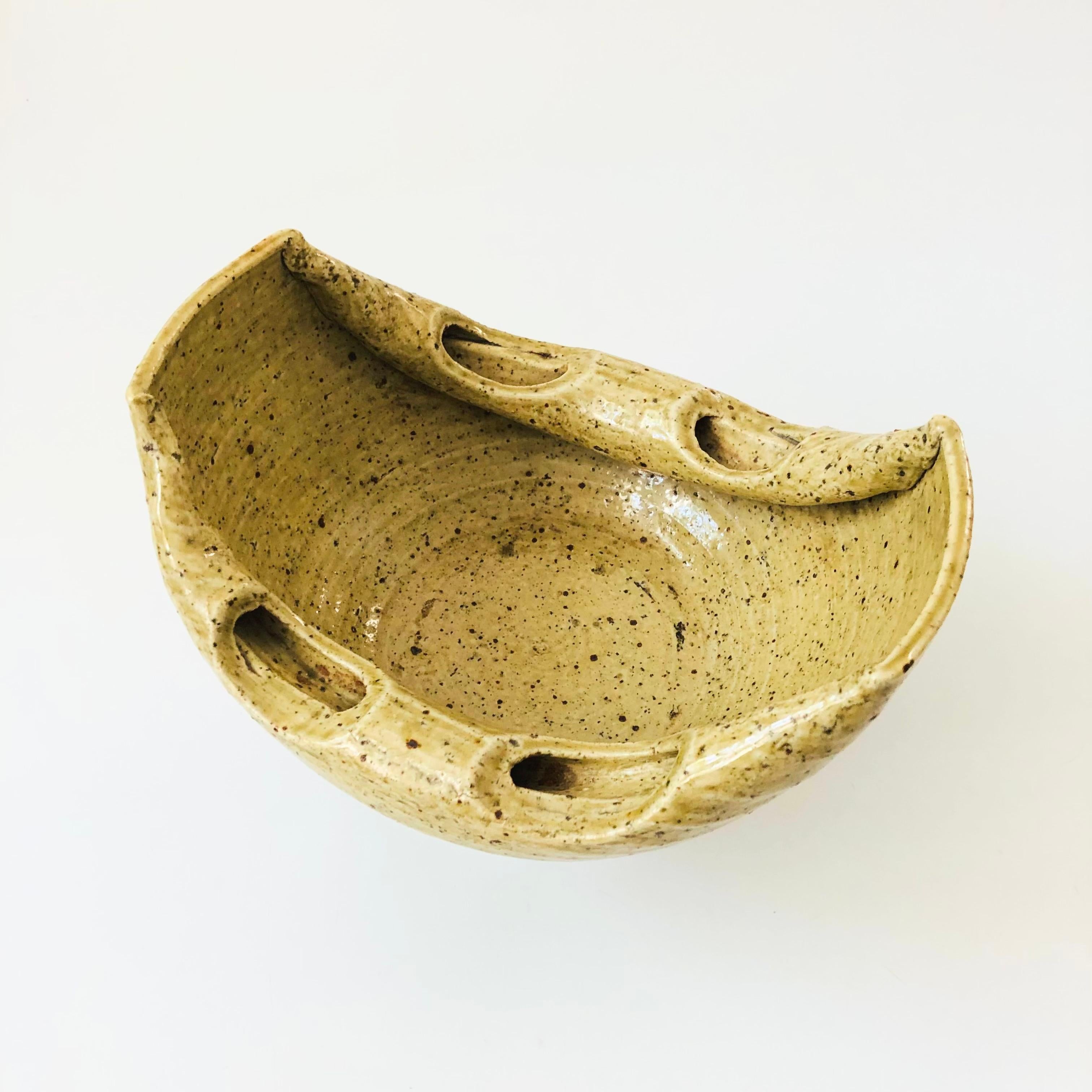 Eine Ikebana-Keramikschüssel im Vintage-Stil auf einem Sockel. Naturfarbene Glasur mit einem strukturierten Band an der Oberseite des Sockels. Einzigartiges gefaltetes Design entlang des Randes. Auf der Unterseite vom Hersteller gestempelt. Perfekt