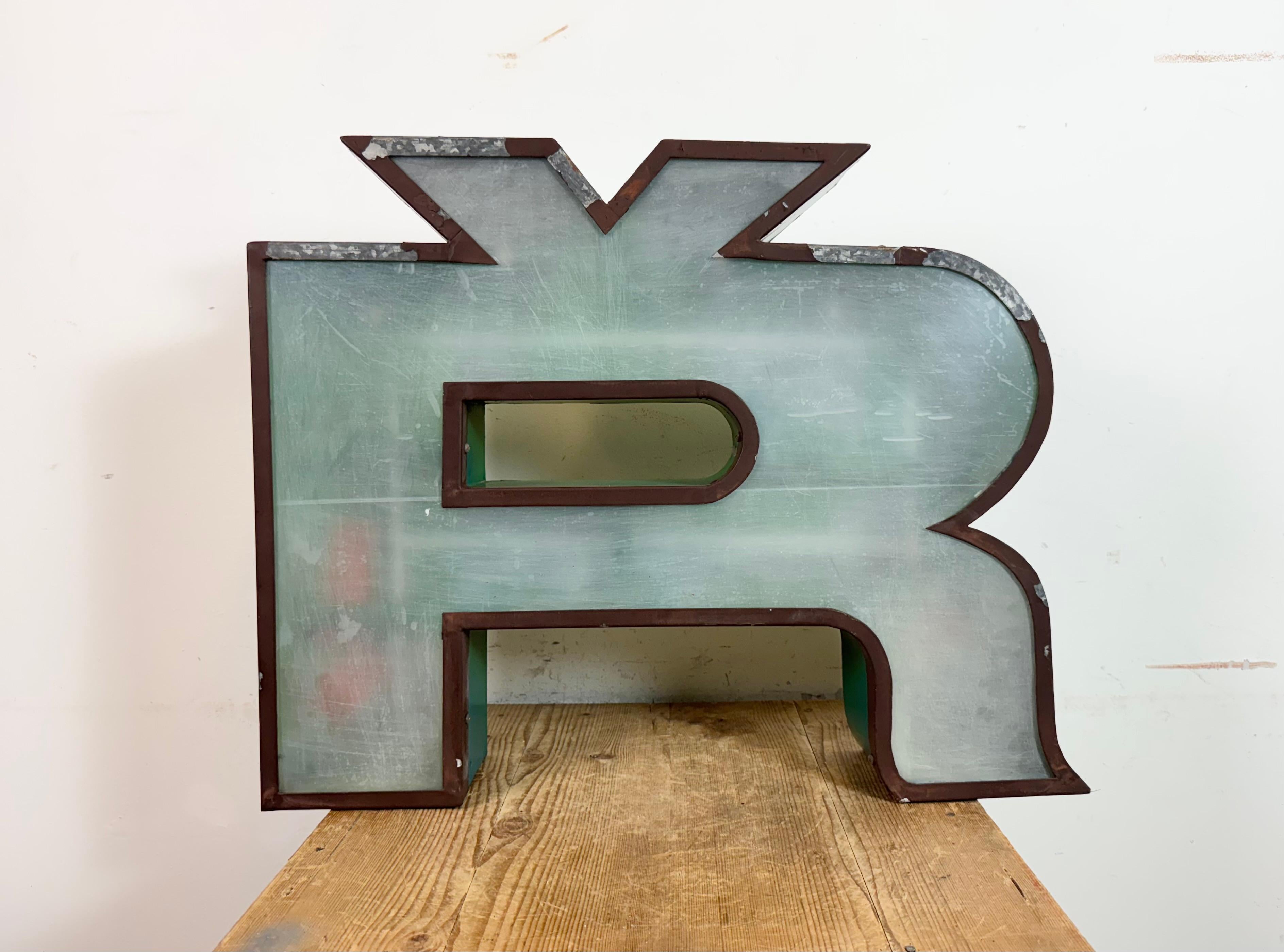 This vintage industrial illuminated letter Ř was made in former Czechoslovakia during the 1960s and comes from an old advertising banner. It features a metal body and a plexiglass cover. It is equipped with a LED strip. The letter can be used as a