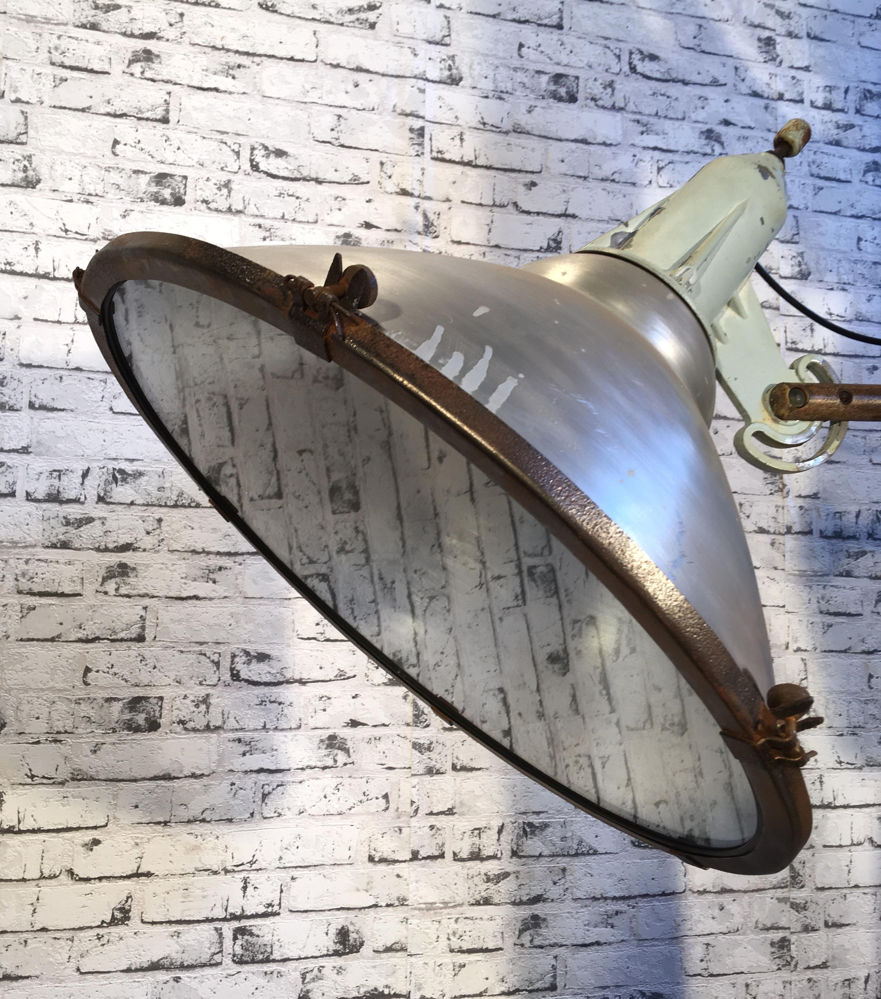 Vintage Czechoslovak factory wall spotlight from 1960s.Spotlight has aluminium shade, cast aluminium top,clear glass cover and iron wall mounting. Fully functional. New porcelain socket E 27 and wire. Weight: 10 kg.