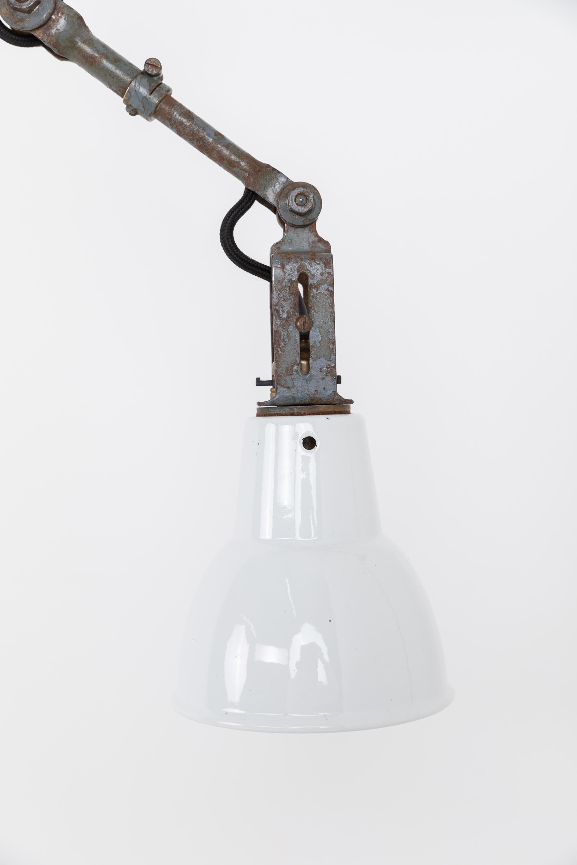 A beautiful example of factory machinists lamp made in England by Dugdills. c.1930

In completely original condition with factory applied paint with nice overall industrial patina. Fully articulating and very versatile - it could be desk, wall or