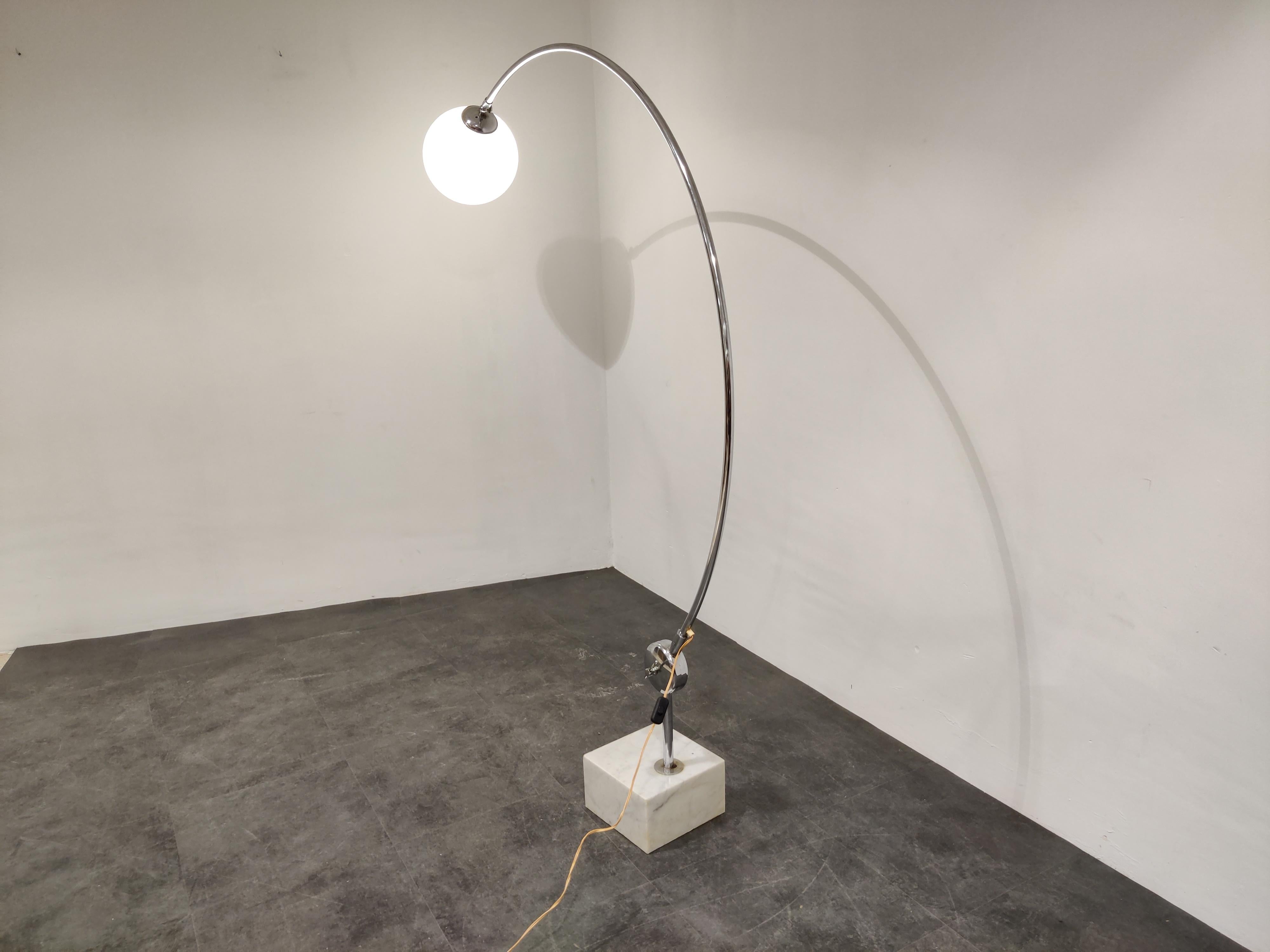 Midcentury chromed 'arched' floor lamp with a white marble base and an opaline globe.

The lamp emits a warm welcoming light because of the glass globe.

Tested and ready to use, works with a regular E27(E26) light bulb.

The floor lamp is