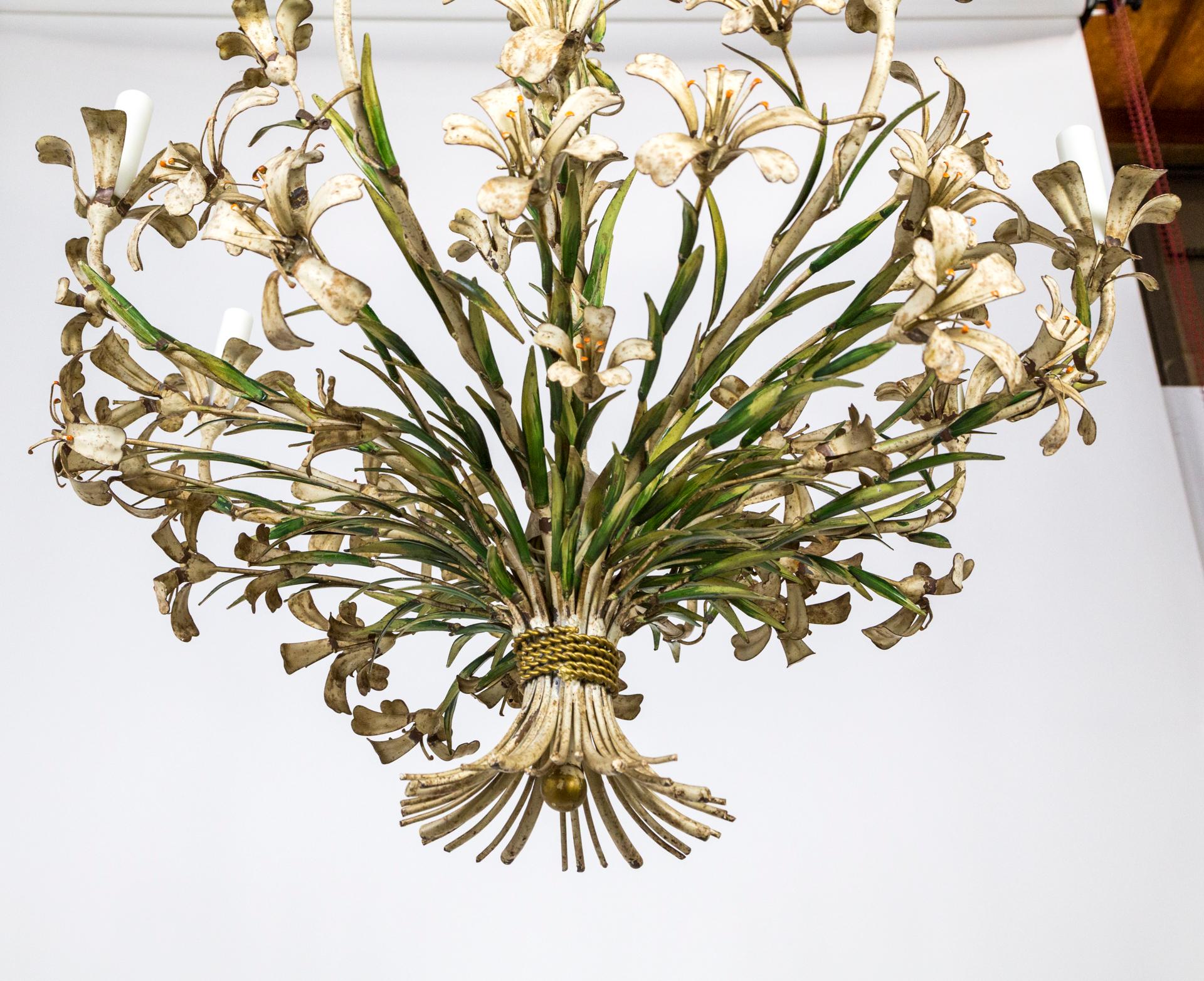 A beautiful example of Italian tole chandeliers, this circa 1940s piece is a large bouquet- completely flowers and leaves, traveling all the way up the stem, with gold rope detail binding the flower stems. It is large, 40