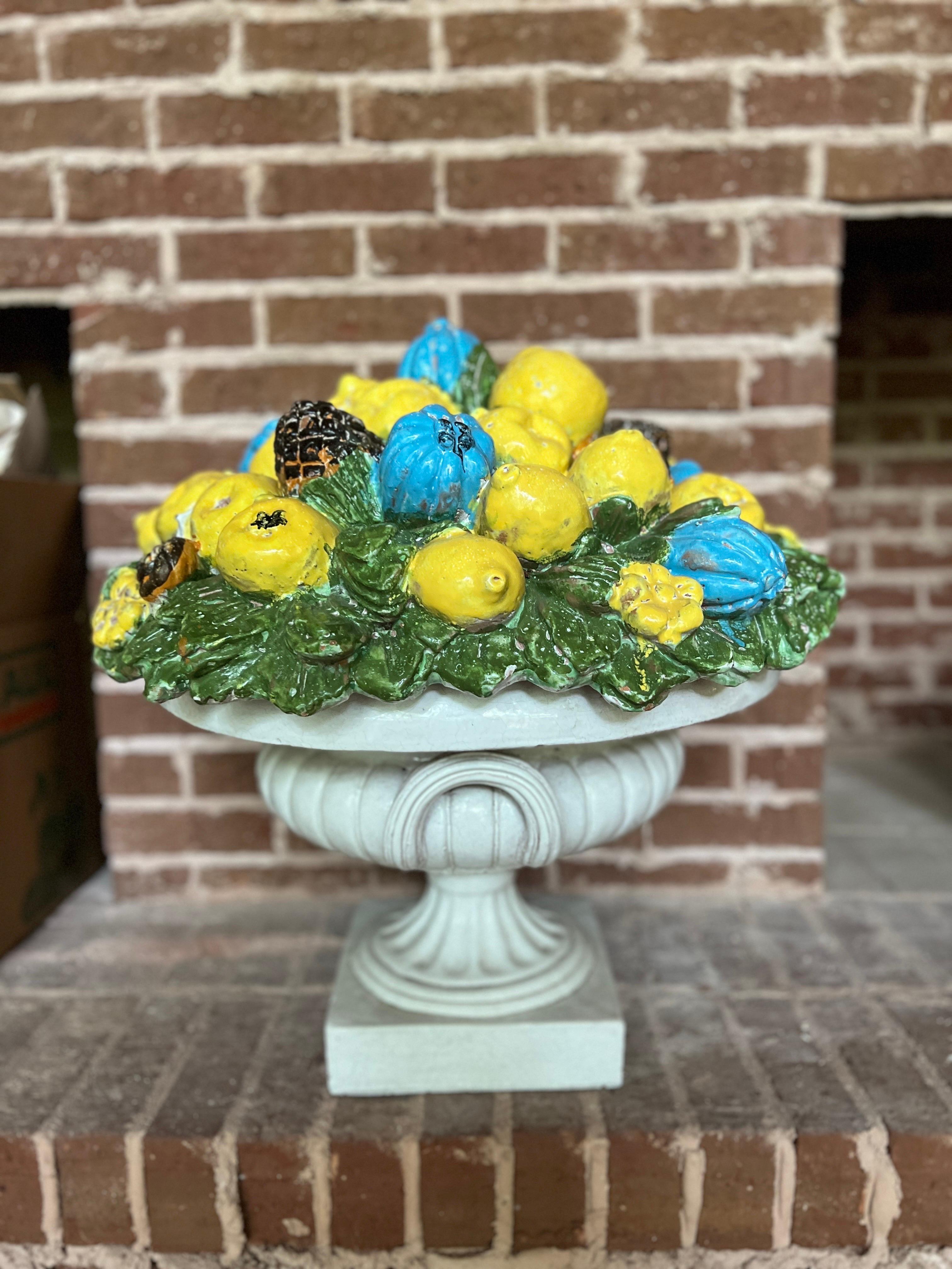 Italian, 20th century.

A very large and good quality Italian delarobia style pottery urn. The centerpiece features a two-part construction with a neoclassical two handled urn and topped with a stunning tri-color top filled with leaves, lemons,