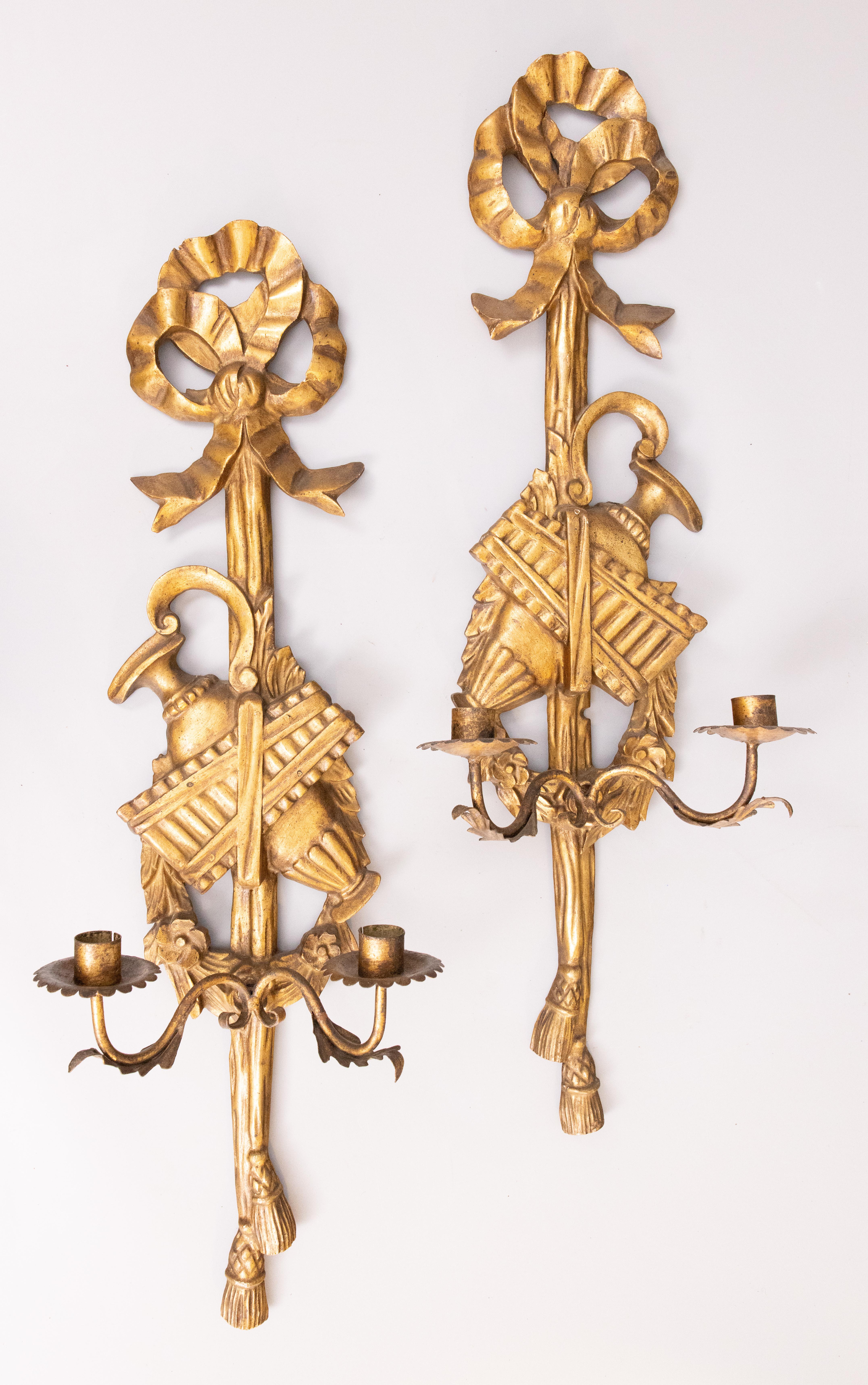 A gorgeous pair of Mid-Century Neoclassical style Italian giltwood and tole two arm candle wall sconces, circa 1950. One sconce retains the original 