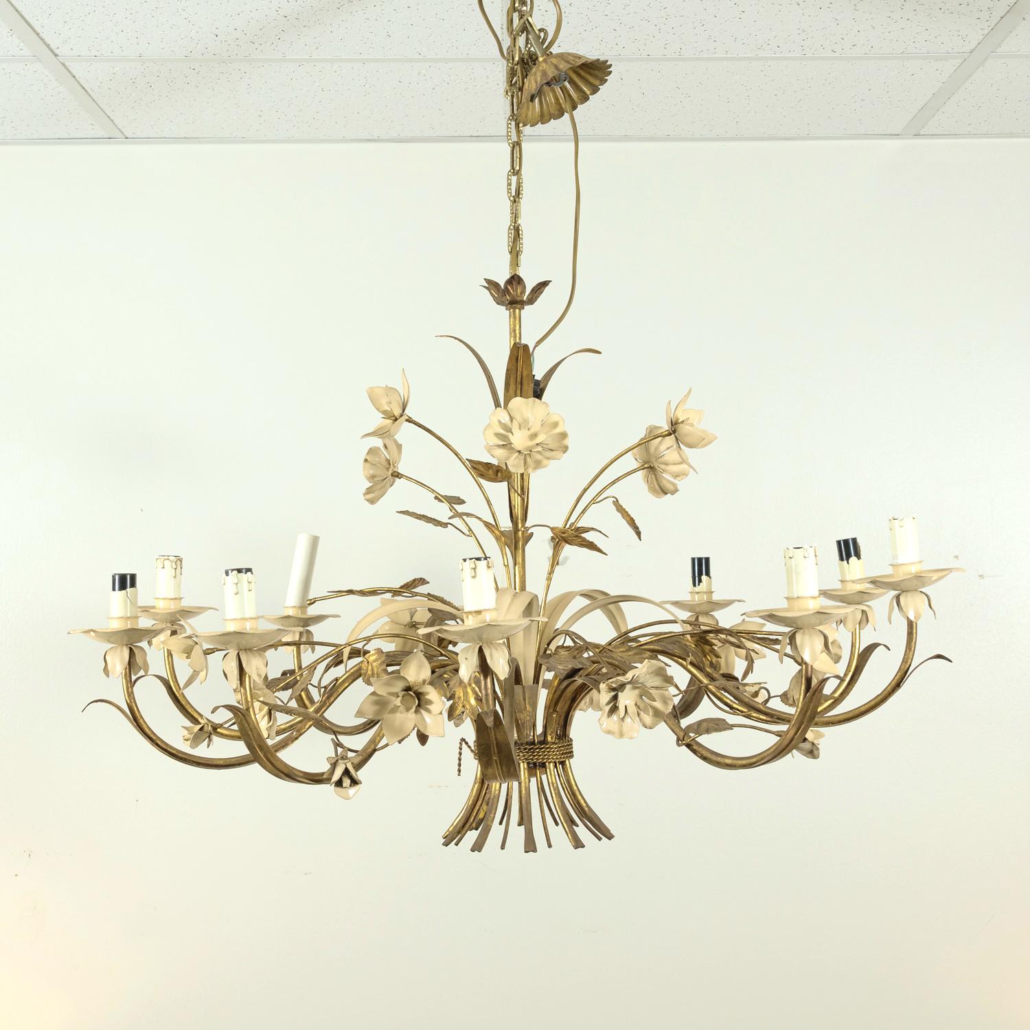 Illuminate your space with the timeless elegance of this large vintage 10-light Italian gilded tole and cream enamel floral chandelier, circa 1970s. A stunning example of Hollywood Regency style, this chandelier features gracefully scrolling gilded