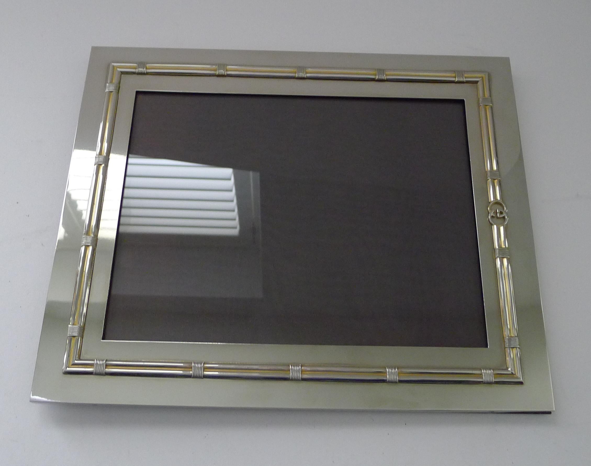 Una magnifica cornice vintage per fotografie o immagini della famosa casa di moda italiana Gucci.

Realizzato in lastra d'argento e rifinito con oro o doratura, la decorazione in rilievo incorpora l'ambitissimo logo GG.  La cornice è anche firmata