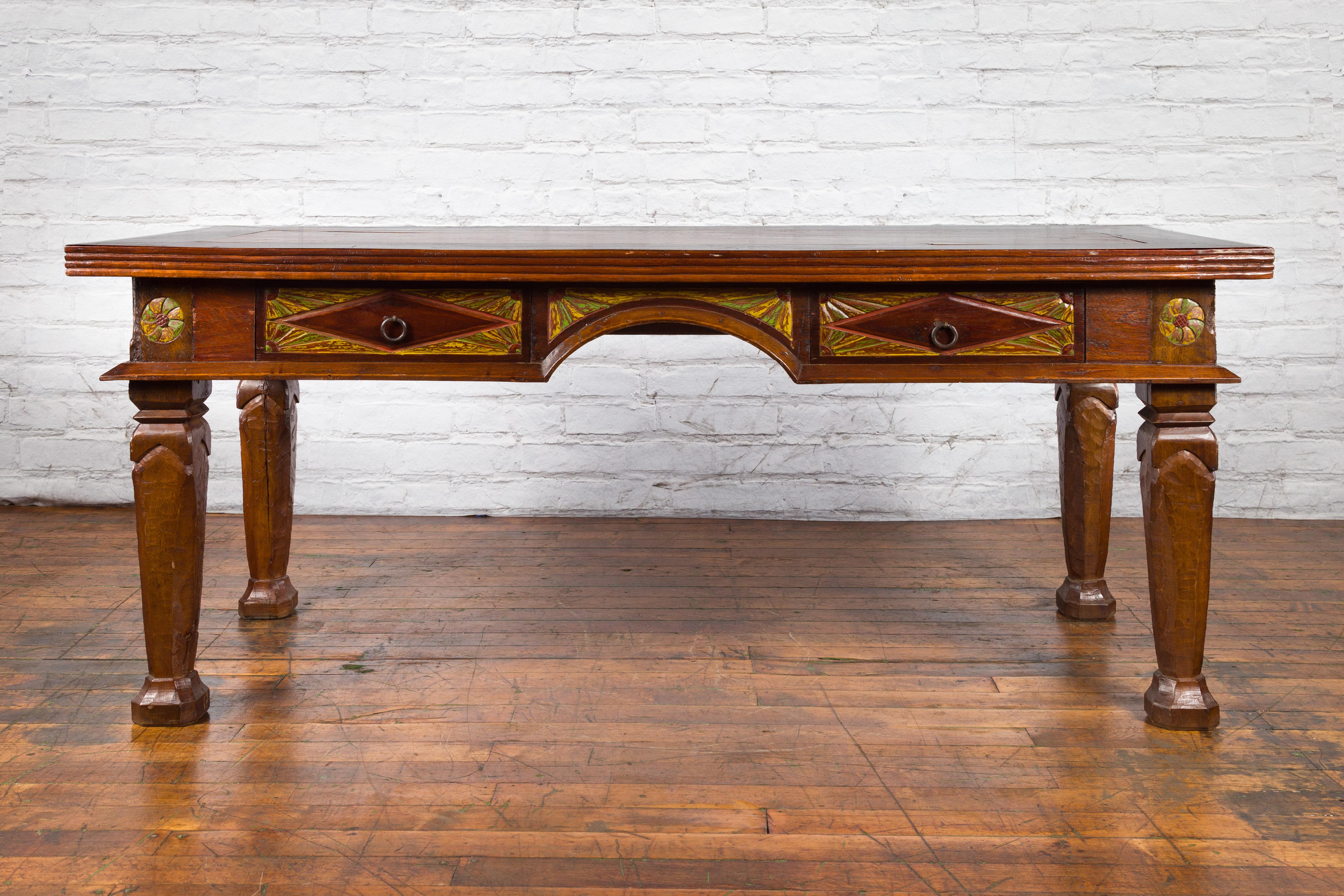 A large vintage Dutch Colonial style teak wood desk from the mid-20th century, with burl wood inset, carved and painted drawers. Created in Java during the mid-century period, this large Dutch Colonial desk features a rectangular burl wood top with