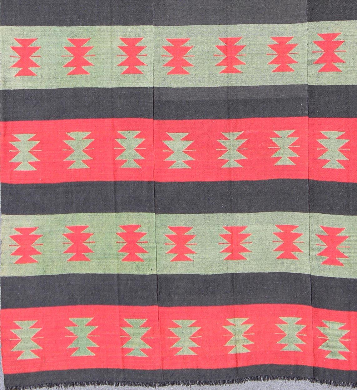 Vintage Turkish Kilim rug with tribal shapes and horizontal stripes in red and green, rug emd-3428, country of origin / type: Turkey / Kilim, circa mid-20th century.

Featuring tribal shapes rendered in a repeating horizontal stripe design, this