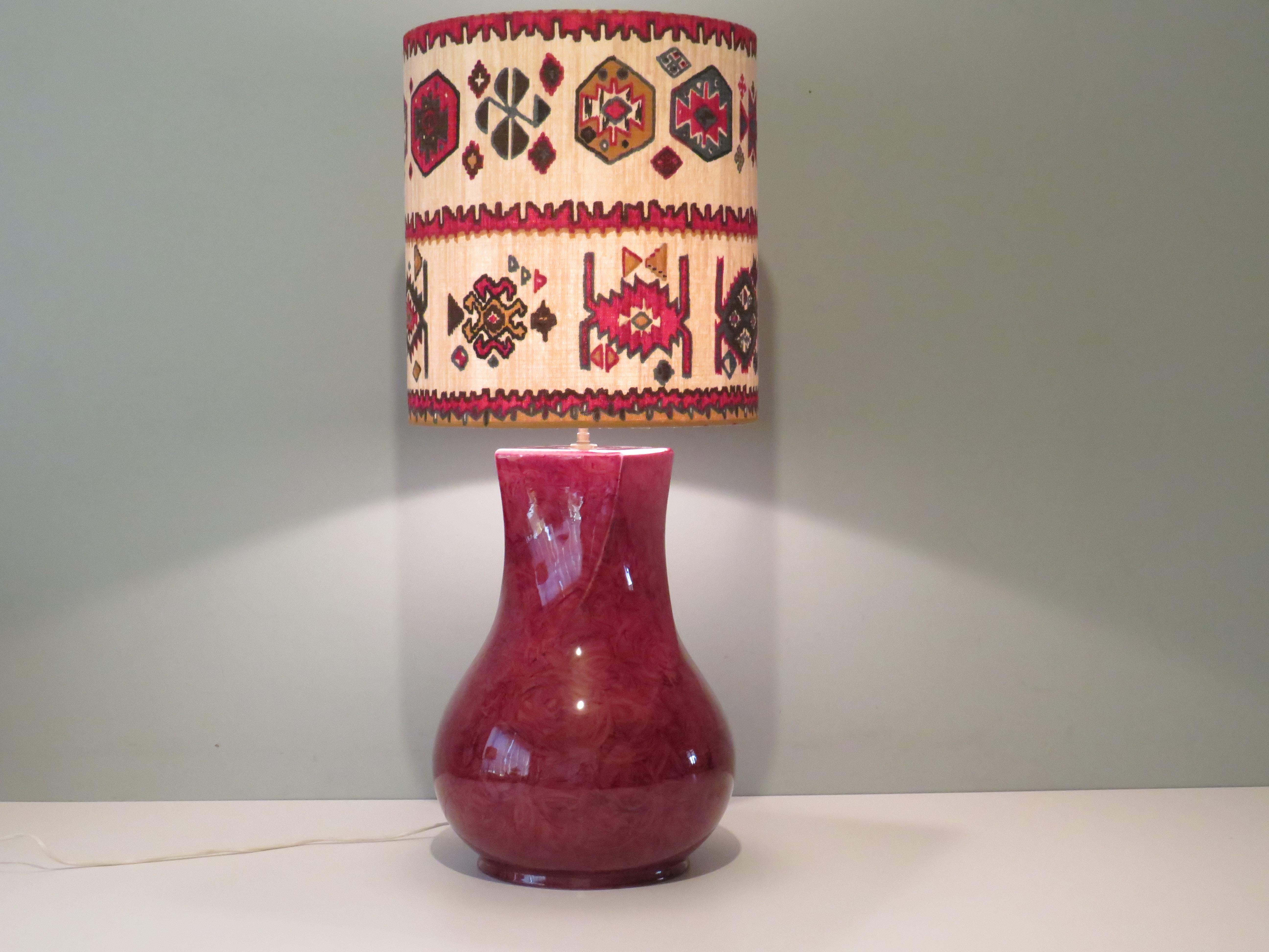 The vintage lamp base from Kostka, France has a red-black glaze layer and a round base that is twisted into a square top surface. The custom-made lampshade is made of a vintage ikat fabric.
The total height of the table lamp is 84 cm.
The lamp