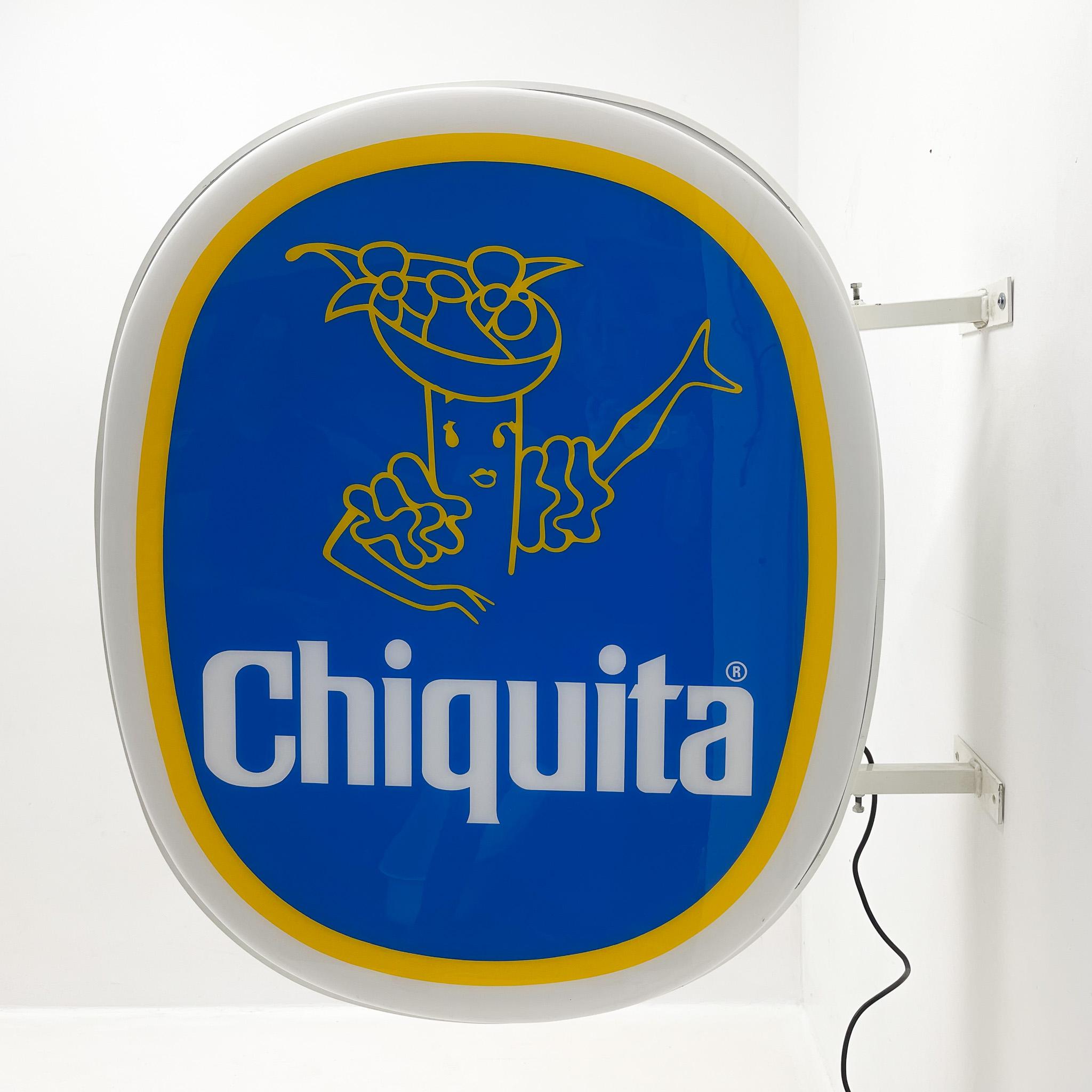 Large wall advertisment light-up sign. This is the first company logo where Miss Chiquita was not a woman, but an animated banana. The logo was used from 1963 to 1987. It lights up from both sides. 
Width 106 cm is measured including wall handels.