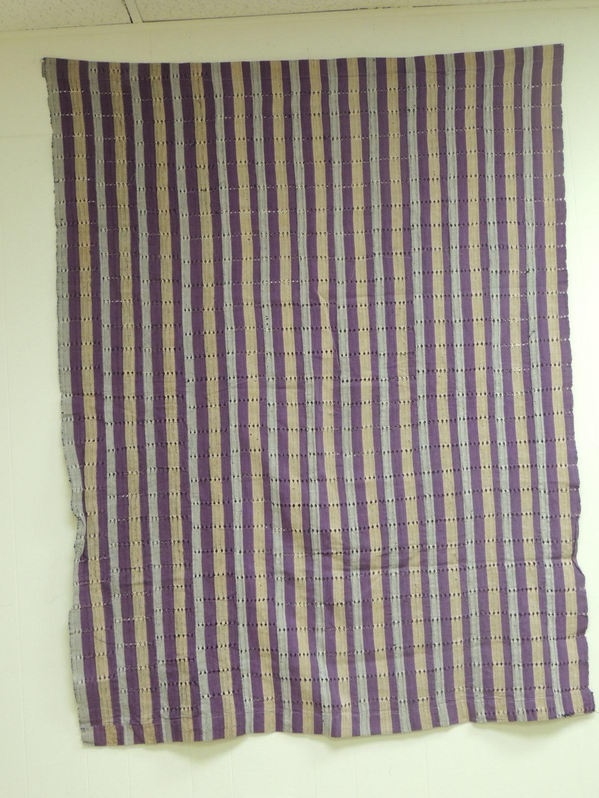 Large vintage Lilac and yellow stripe Yoruba African Textile.
The Yoruba are highly fashion-conscious people. Colors change from season to season and such non-traditional fibers as Lurex can be introduced
into strip woven cloth. A common form of